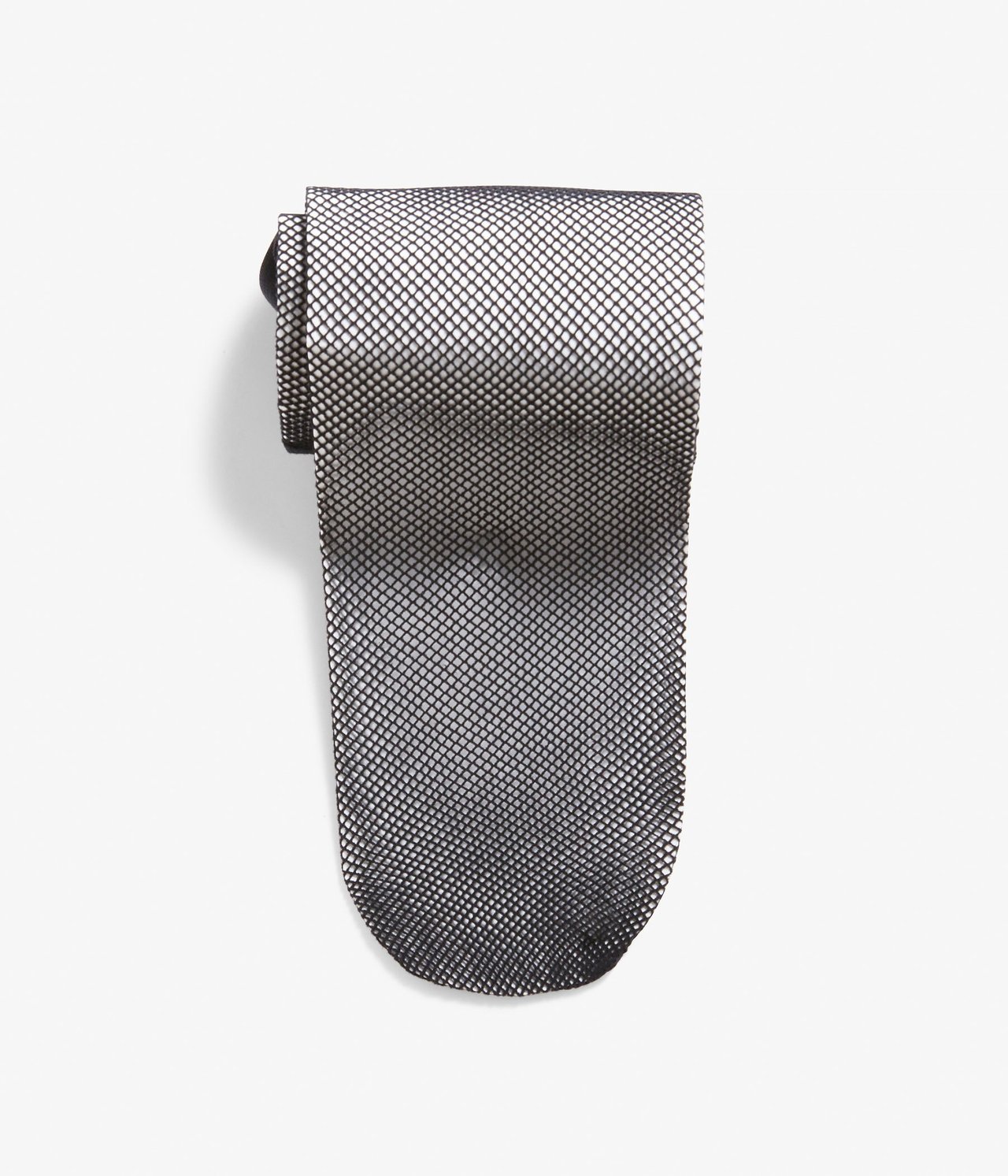 Ylhäältä näkymä mustista verkkosukkahousuista, taiteltuna ja kuvioitua pintaa näyttäen.