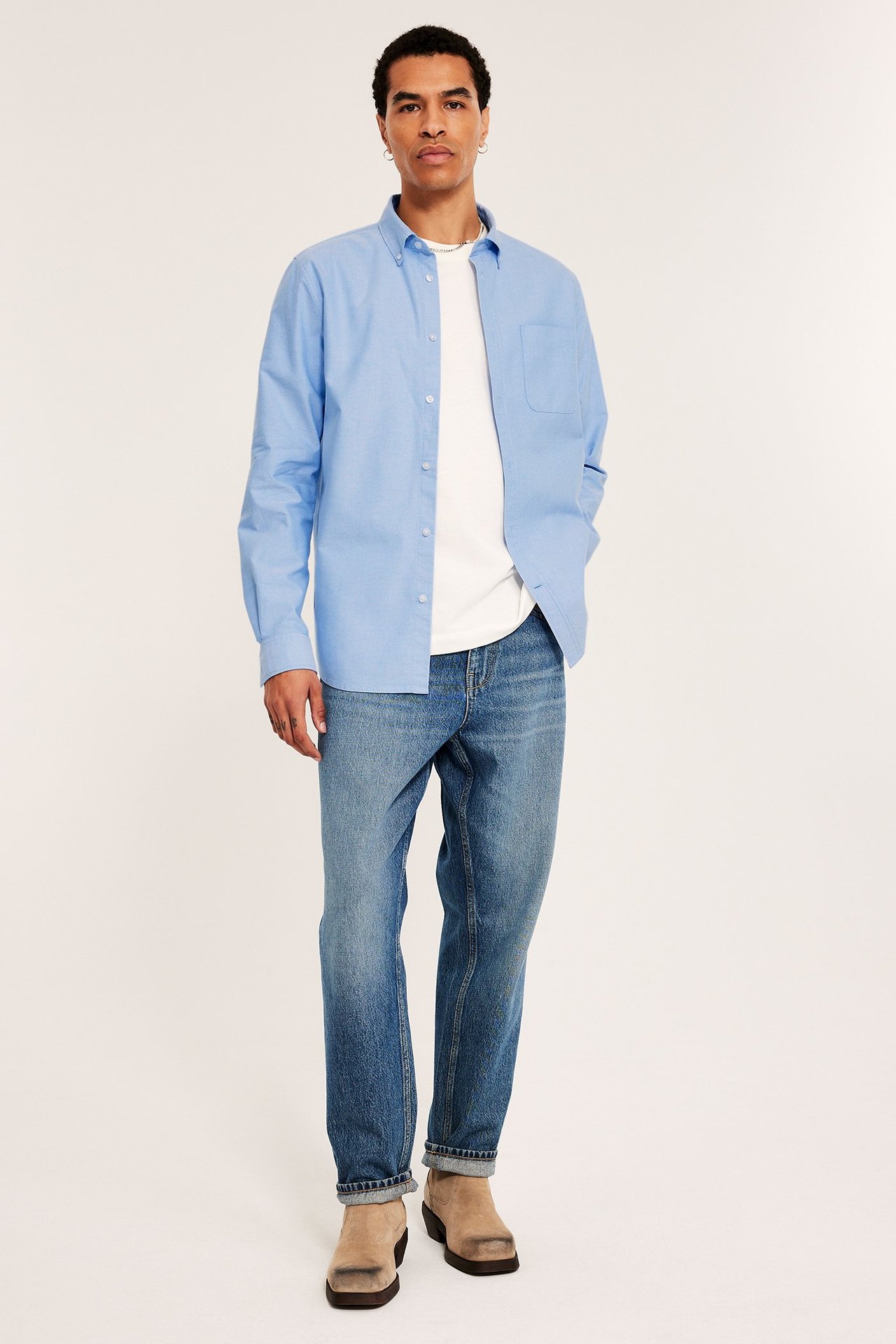 Ljusblå oxfordskjorta med button down-krage och brustet ficka, regular fit, bärs av man.