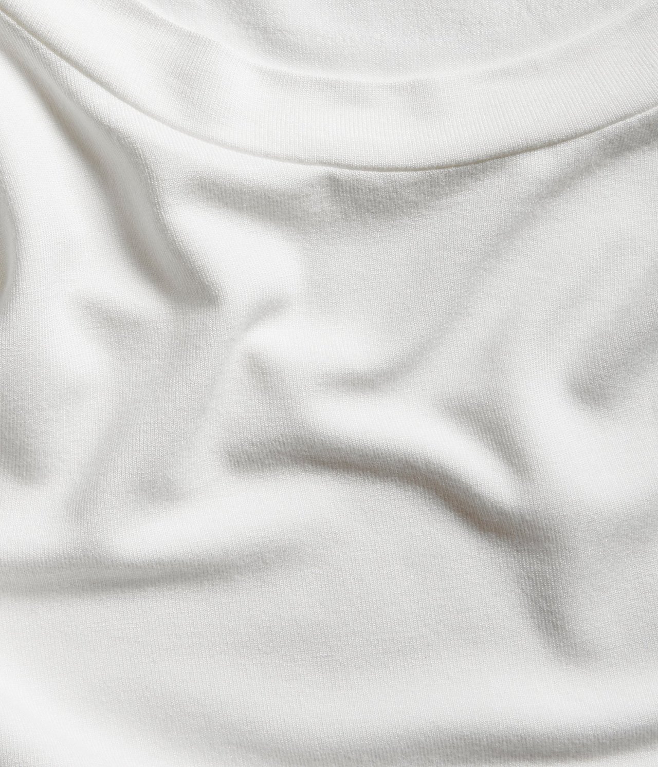 Zbliżenie na dopasowany, kremowy T-shirt z golfem ze stójką z mieszanki wiskozy.