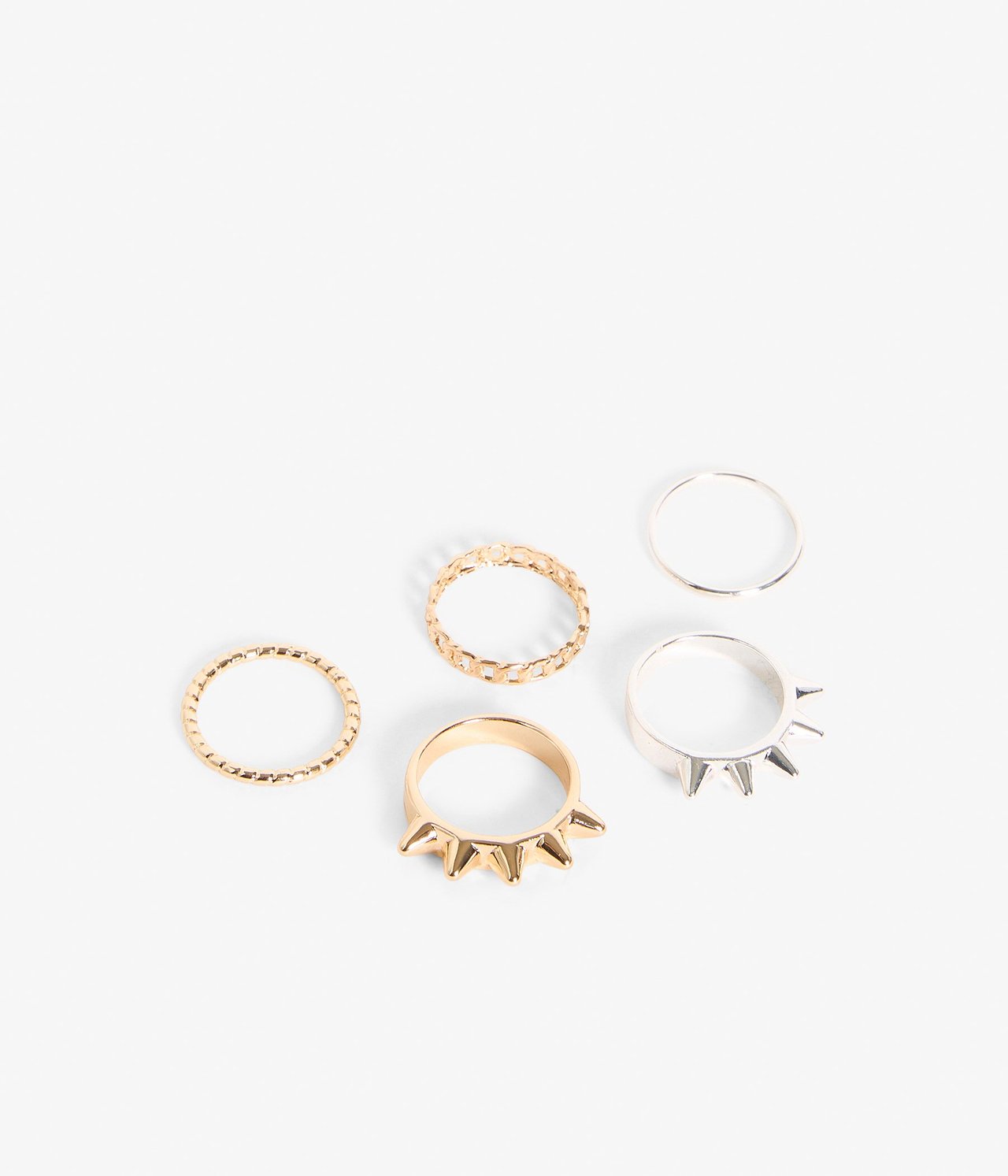 Närbild av ett 5-pack guld- och silverfärgade ringar med olika texturer och spikar.