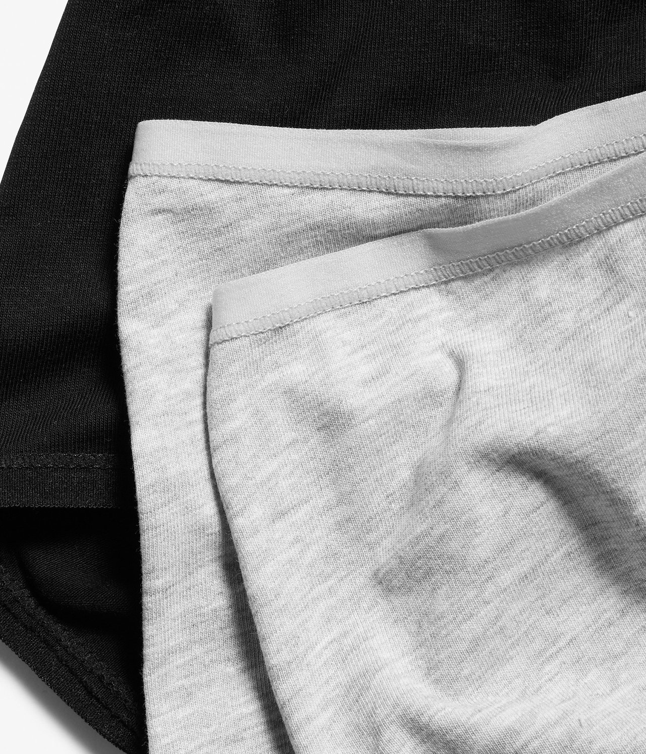 Zbliżenie szarych melanżowych bawełnianych majtek z czarnymi majtkami pod spodem.