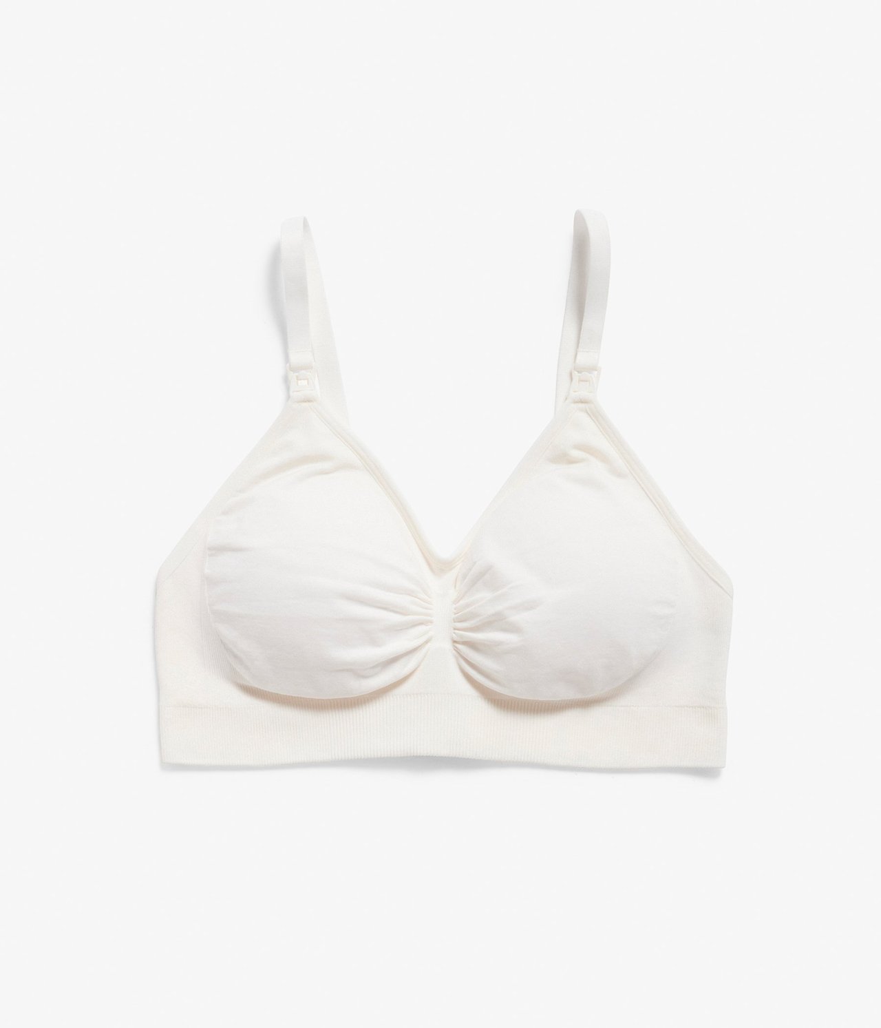 Framifrån, vit sömlös amnings-bh med justerbara axelband och spännen.