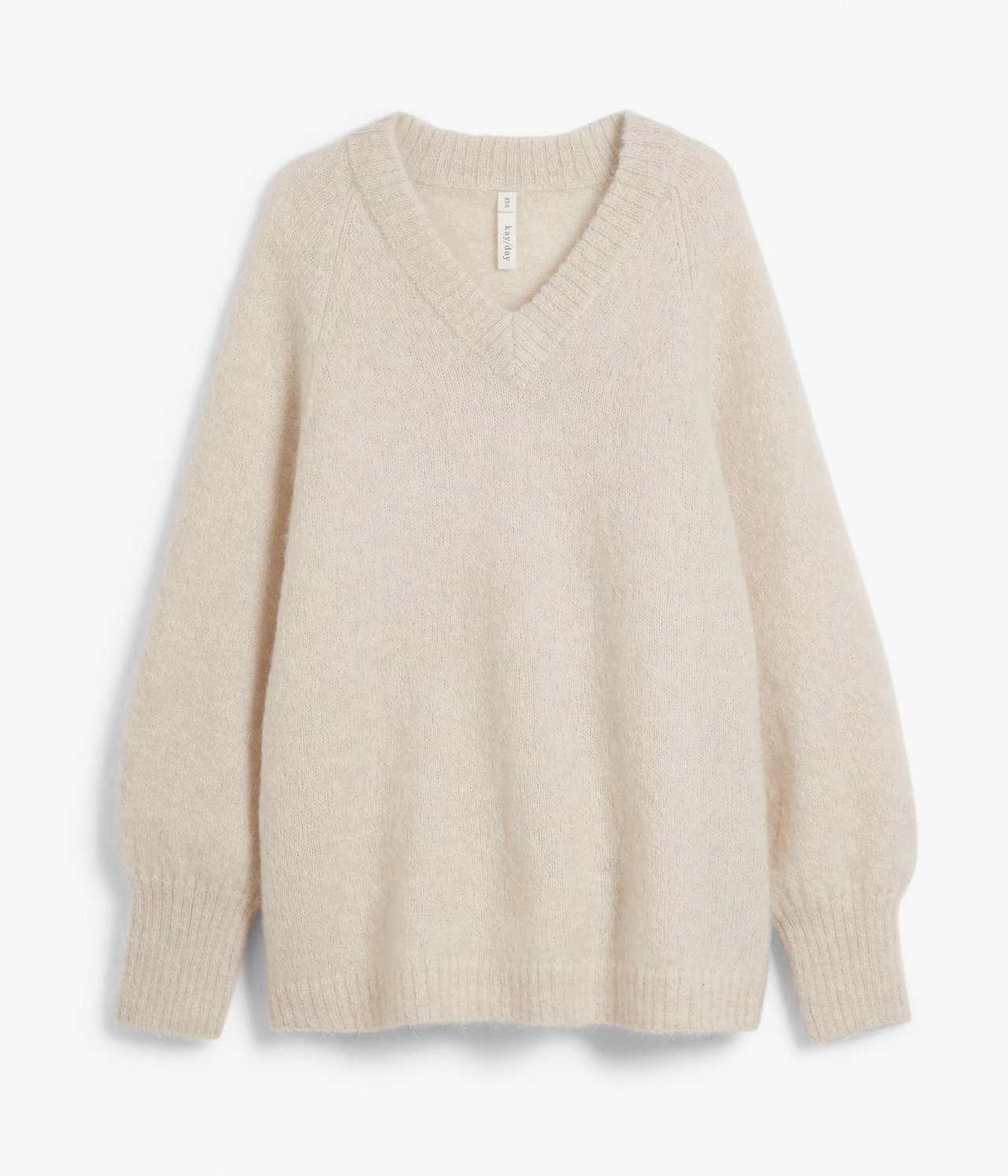 Frontvisning av en oversized lys beige melert V-hals strikkegenser i myk ullblanding.