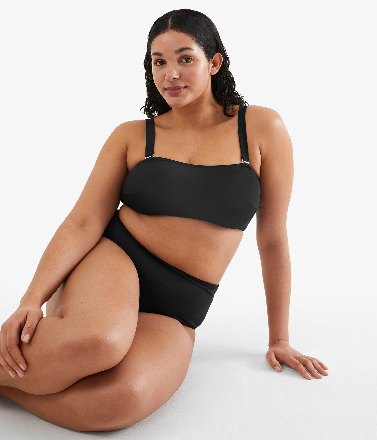 Frontvisning: Kvinne i svart strukturert bandeau-bikinitopp med stropper og matchende truse.