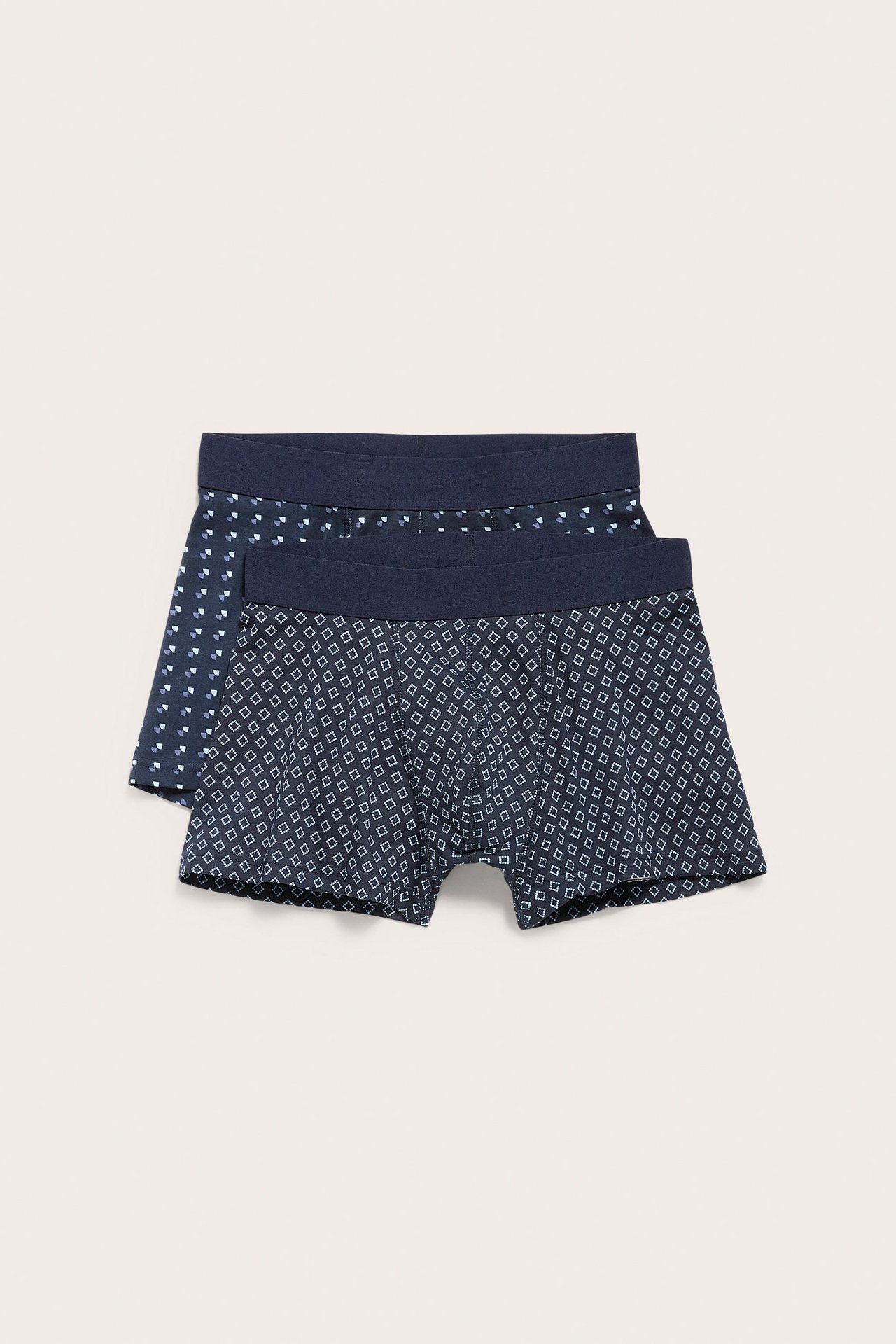 Frontbilde av to par mørkeblå mønstrede boxershorts for menn med elastisk linning.