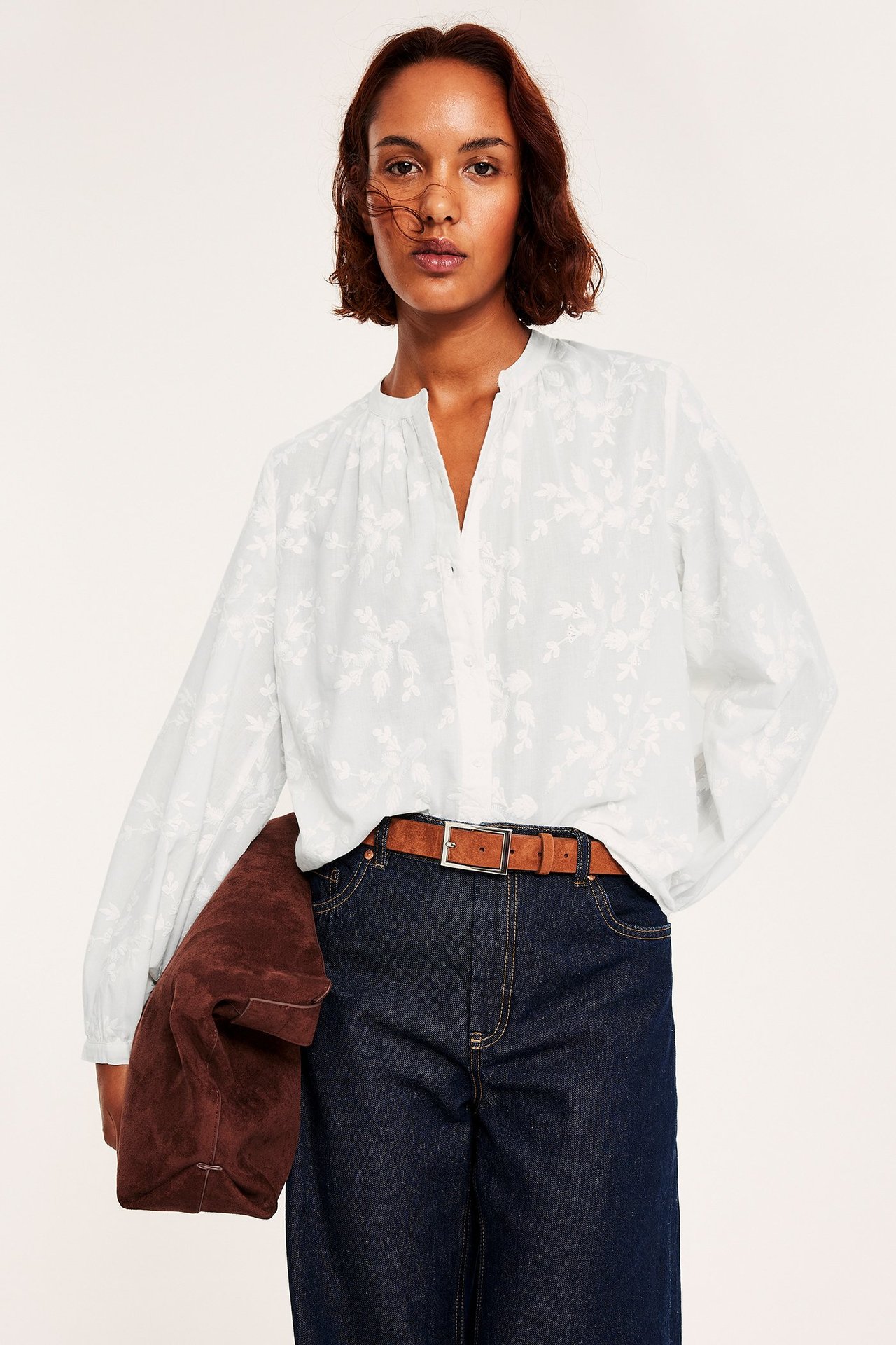 Valkoinen paita nappeilla ja kirjailtu kukkakuvio, pitkähiha, rento istuvuus.