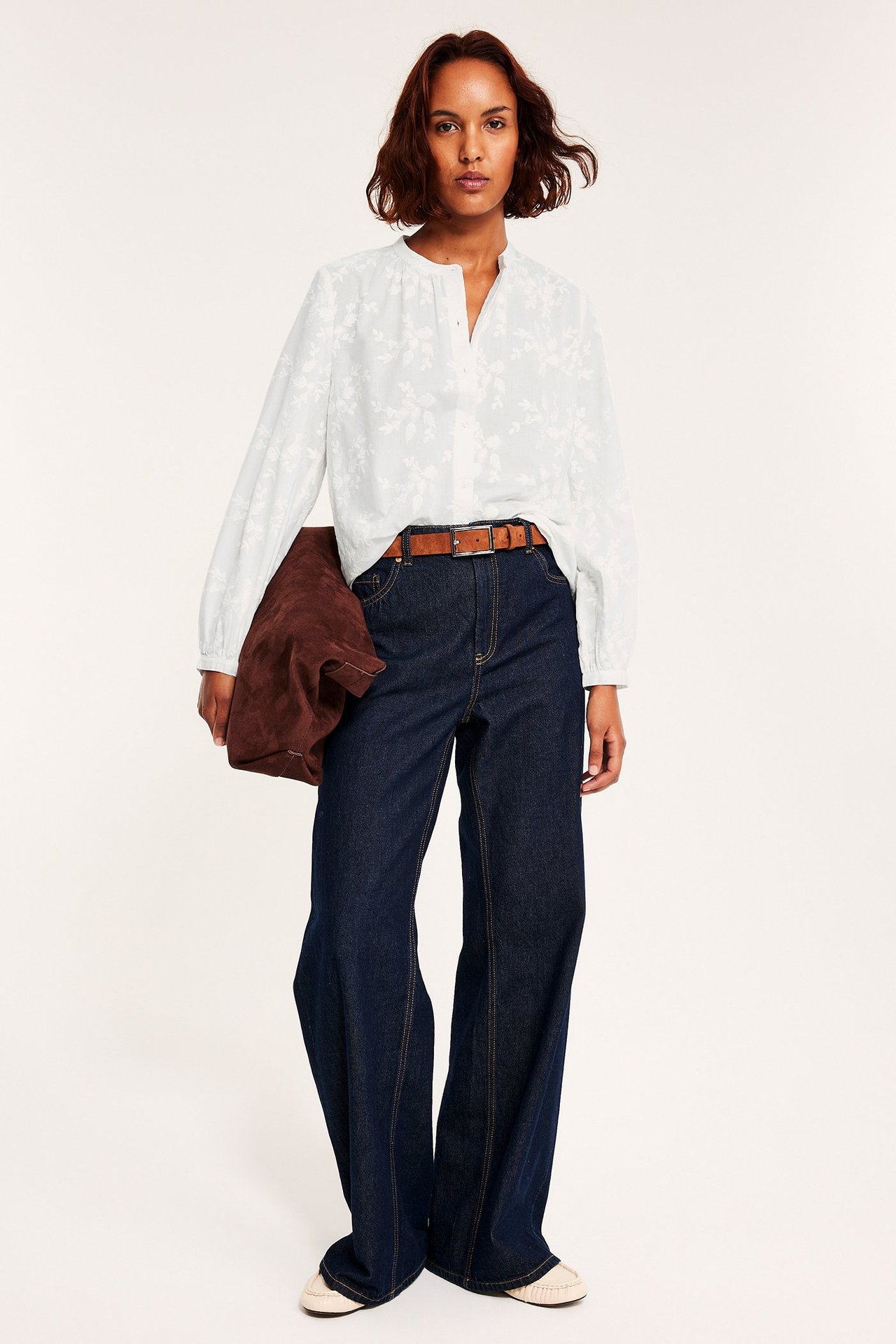 BiałaBluza z guzikami i haftowanymi kwiatami, na kobiecie, luźny krój.