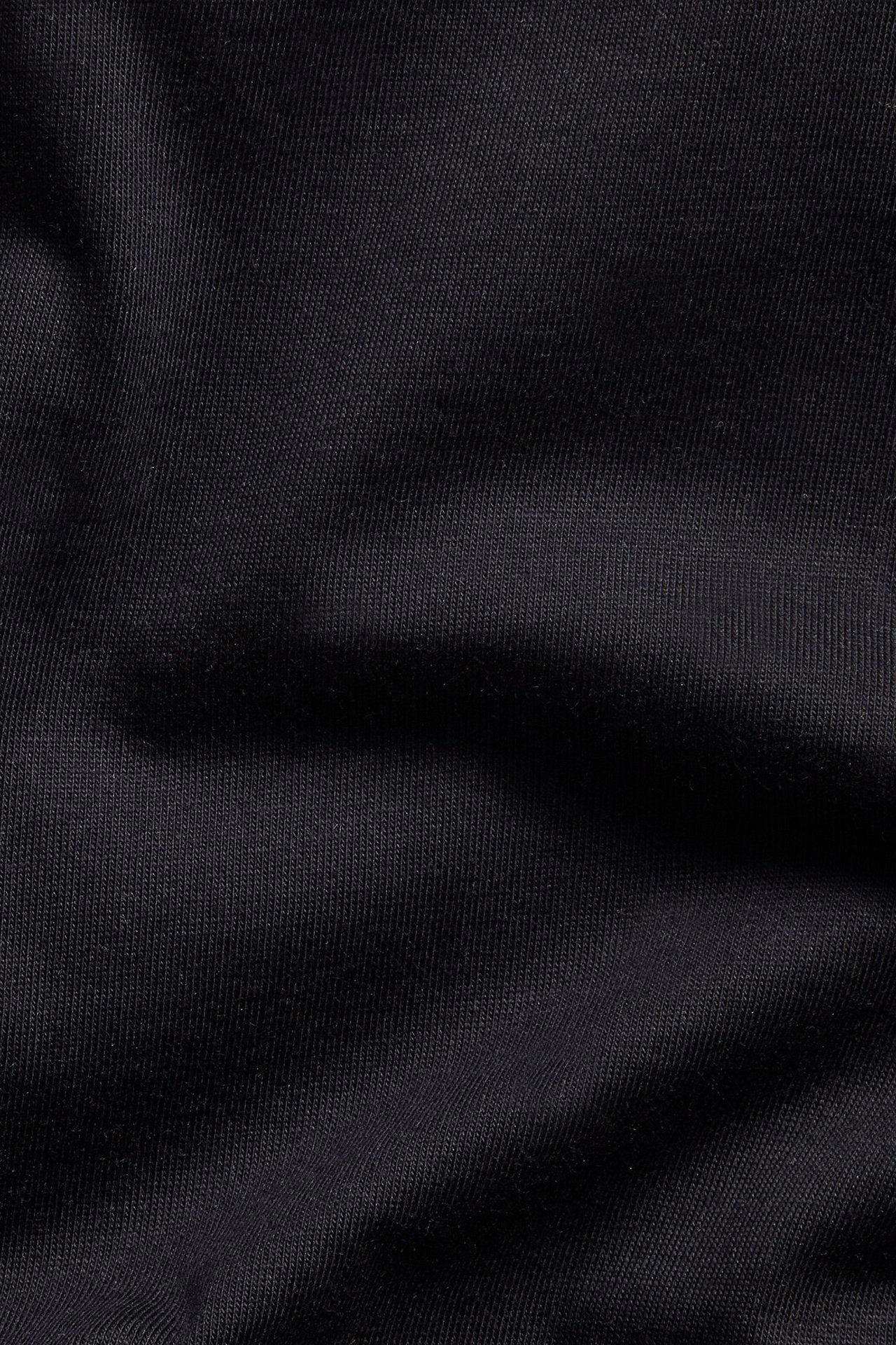 Zbliżenie na czarny, gładki materiał z bawełny organicznej z męskiego T-shirtu z dekoltem w serek.