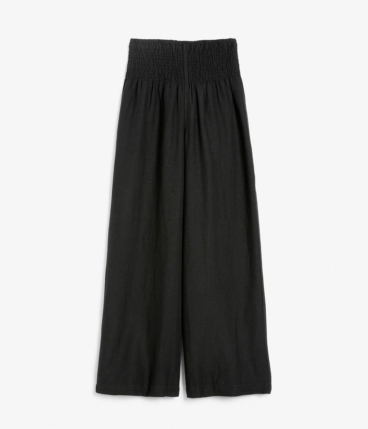 Edestä: mustat leveälahkeiset pellavasekoitehousut, joissa smokkirypytys vyötäröllä.