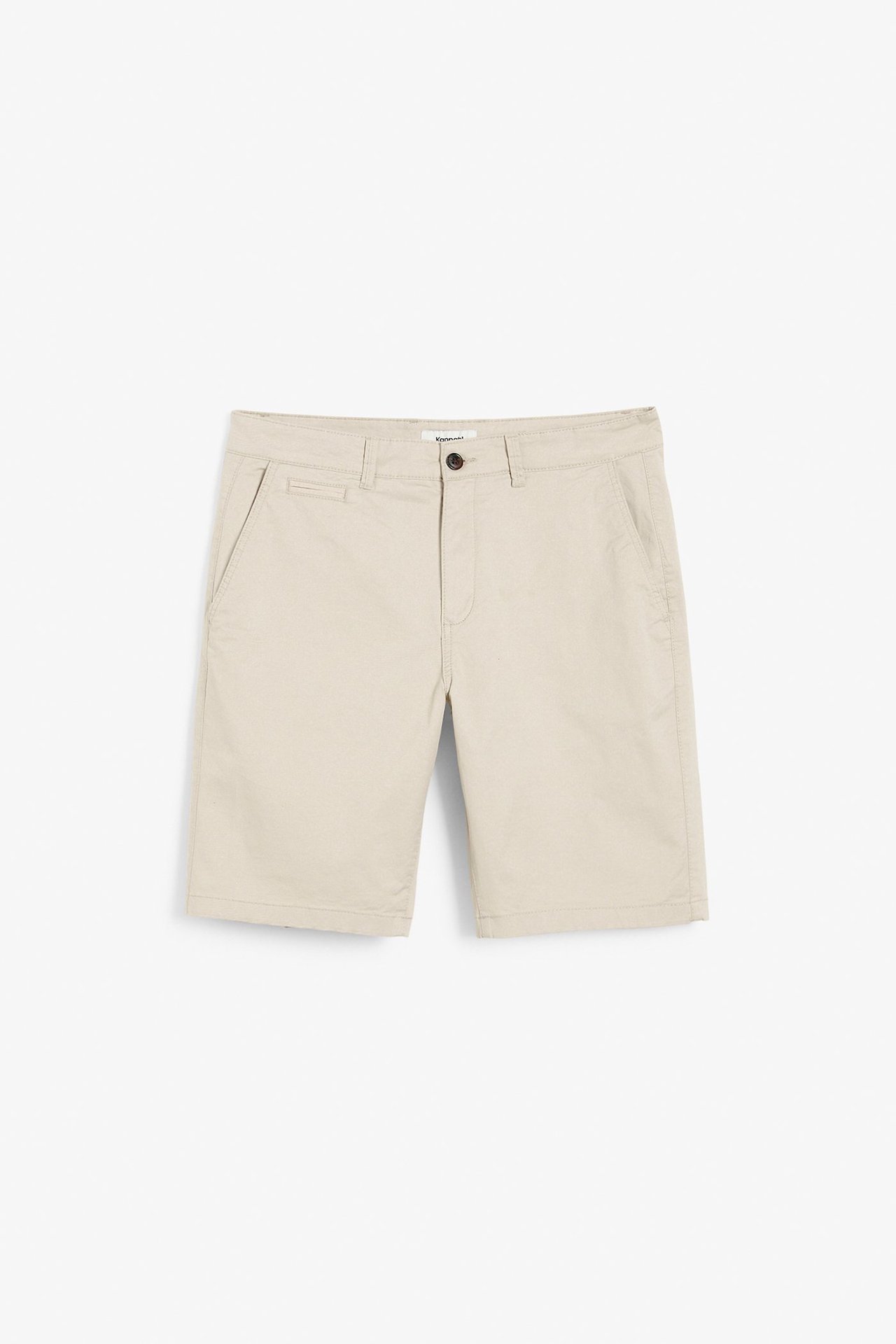 Edestä näkymä vaaleanbeigestä miesten chino-shortseista, joissa nappi- ja vetoketjukiinnitys.
