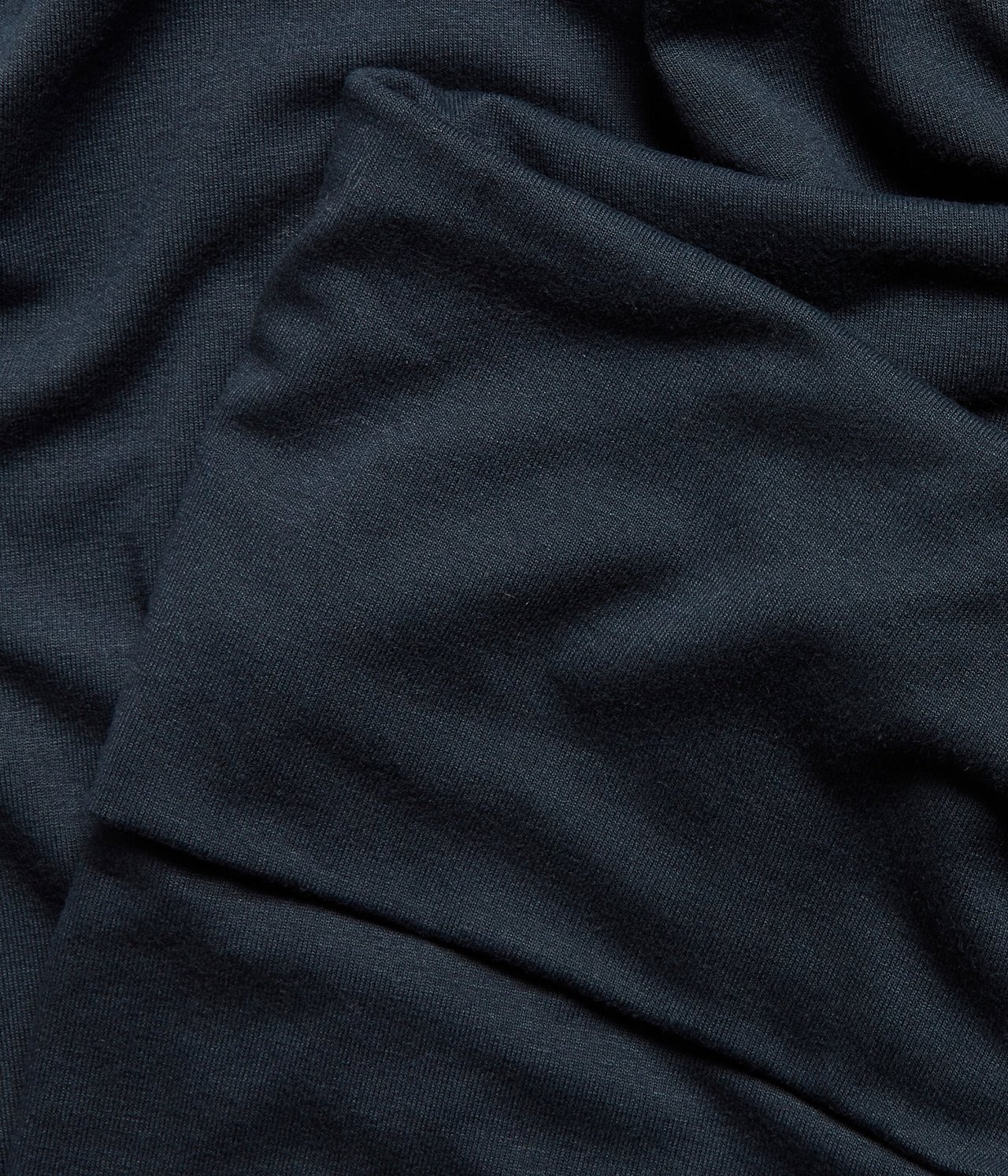 Zbliżenie na ciemnoniebieski, jednolity materiał loungewear z mieszanki wiskozy, miękko udrapowany.