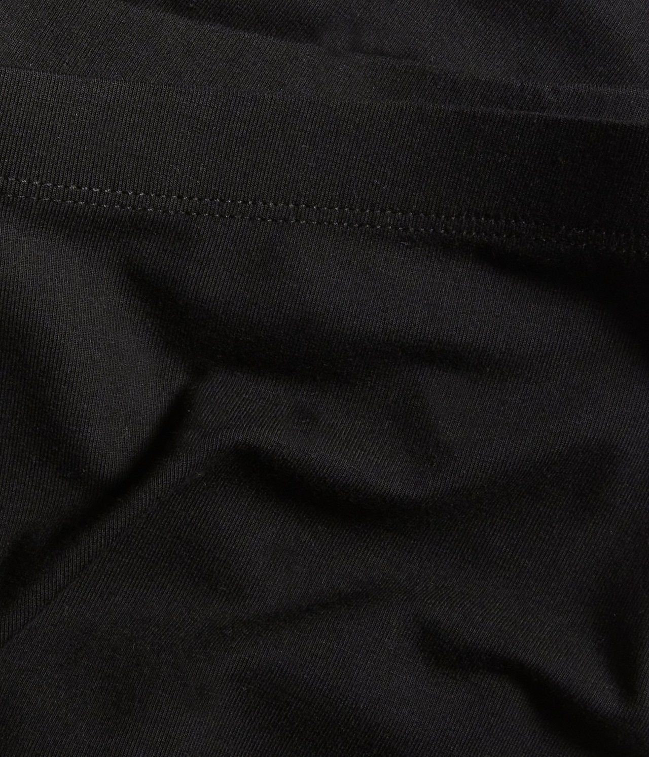 Zbliżenie na czarne legginsy capri z jednolitej mieszanki wiskozy z widocznymi szwami.