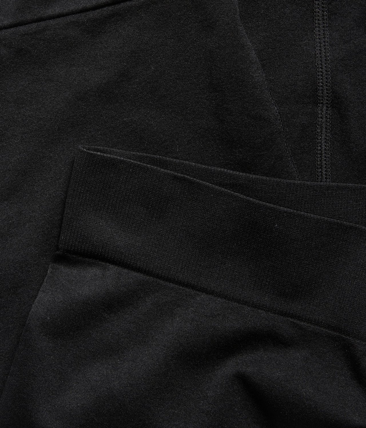 Zbliżenie czarnych bezszwowych szortów z prążkowanym pasem i widocznymi szwami.