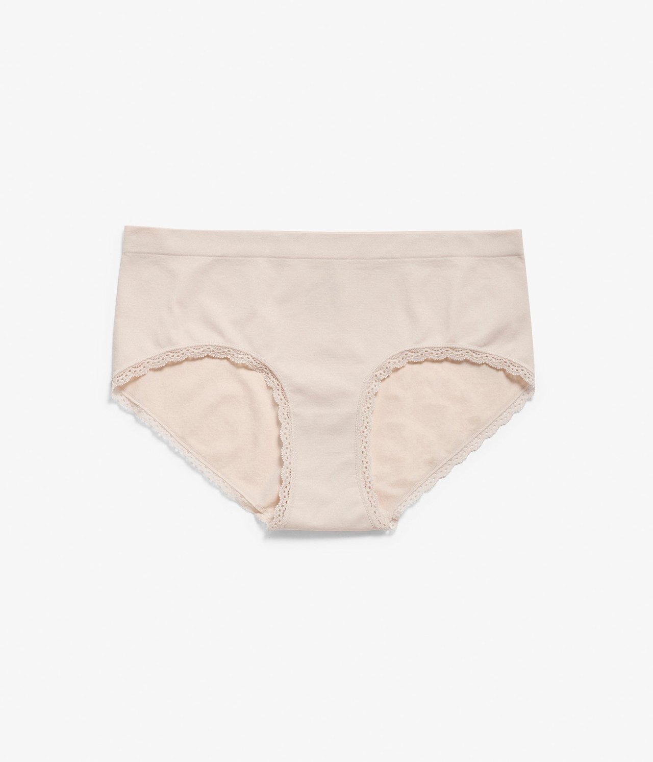 Forfra: Lys beige sømløs hipstertruse med blondedetaljer langs benåpningene.