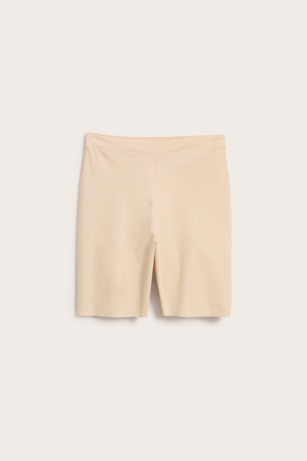 Frontvisning av beige ensfargede shaping-shorts i mykt, elastisk mikrostoff.