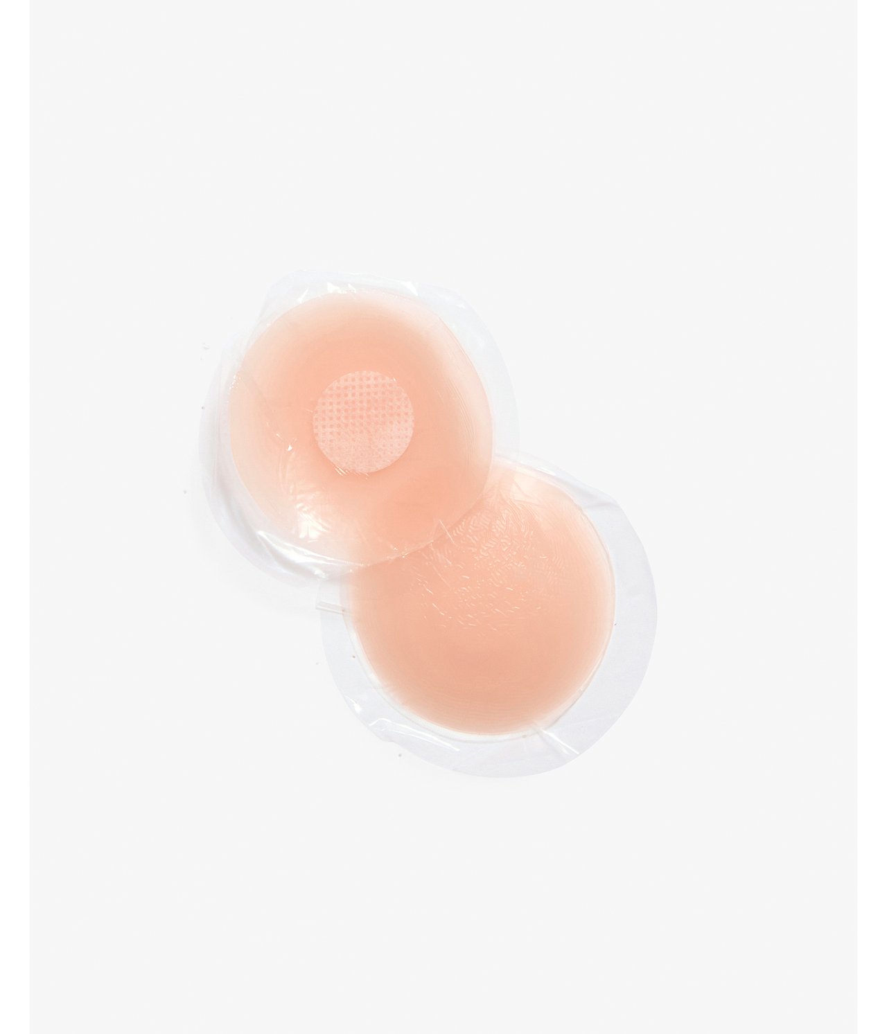 Nærbilde av to runde beige silikon nippelcovers i klar plastemballasje.