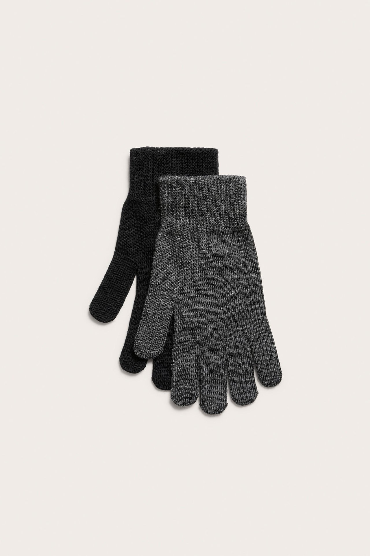 Ylhäältä näkymä kahdesta neulotusta sormikkaasta: yksi tummanharmaa meleerattu ja yksi musta.