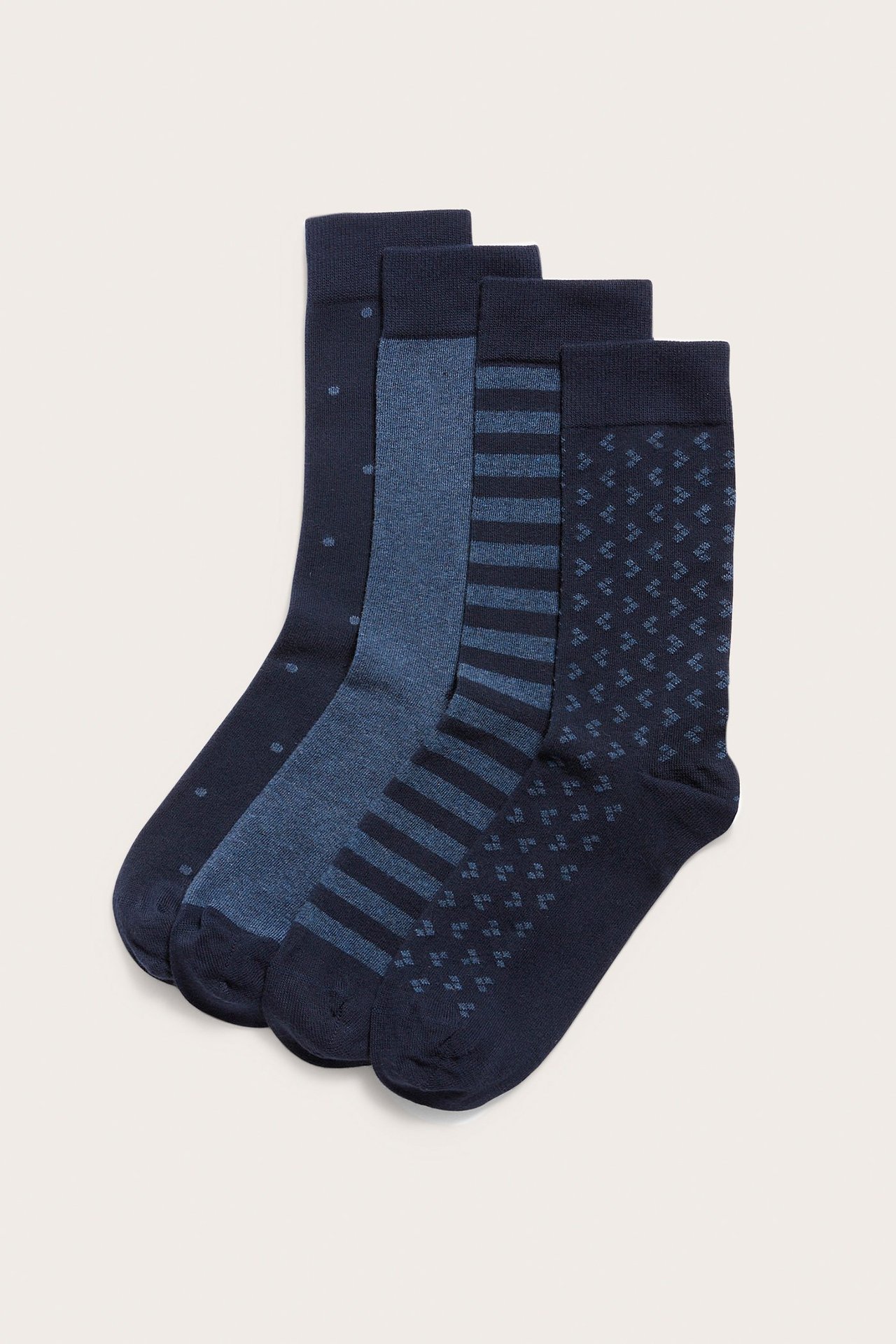 Framifrån, ett fyrpack blåa bomullsstrumpor, varje par med ett unikt mönster.