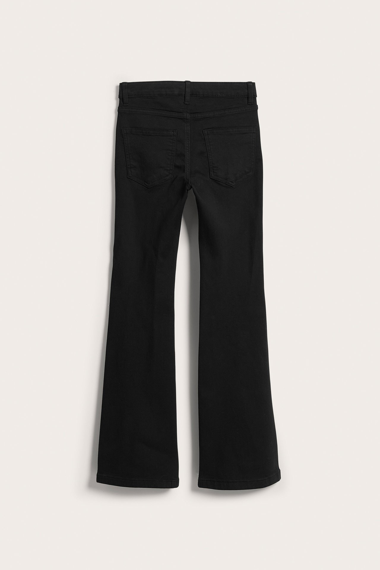 Lasten mustat bootcut-farkut joustavasta denimistä, takaa kuvattuna, keskikorkea vyötärö.