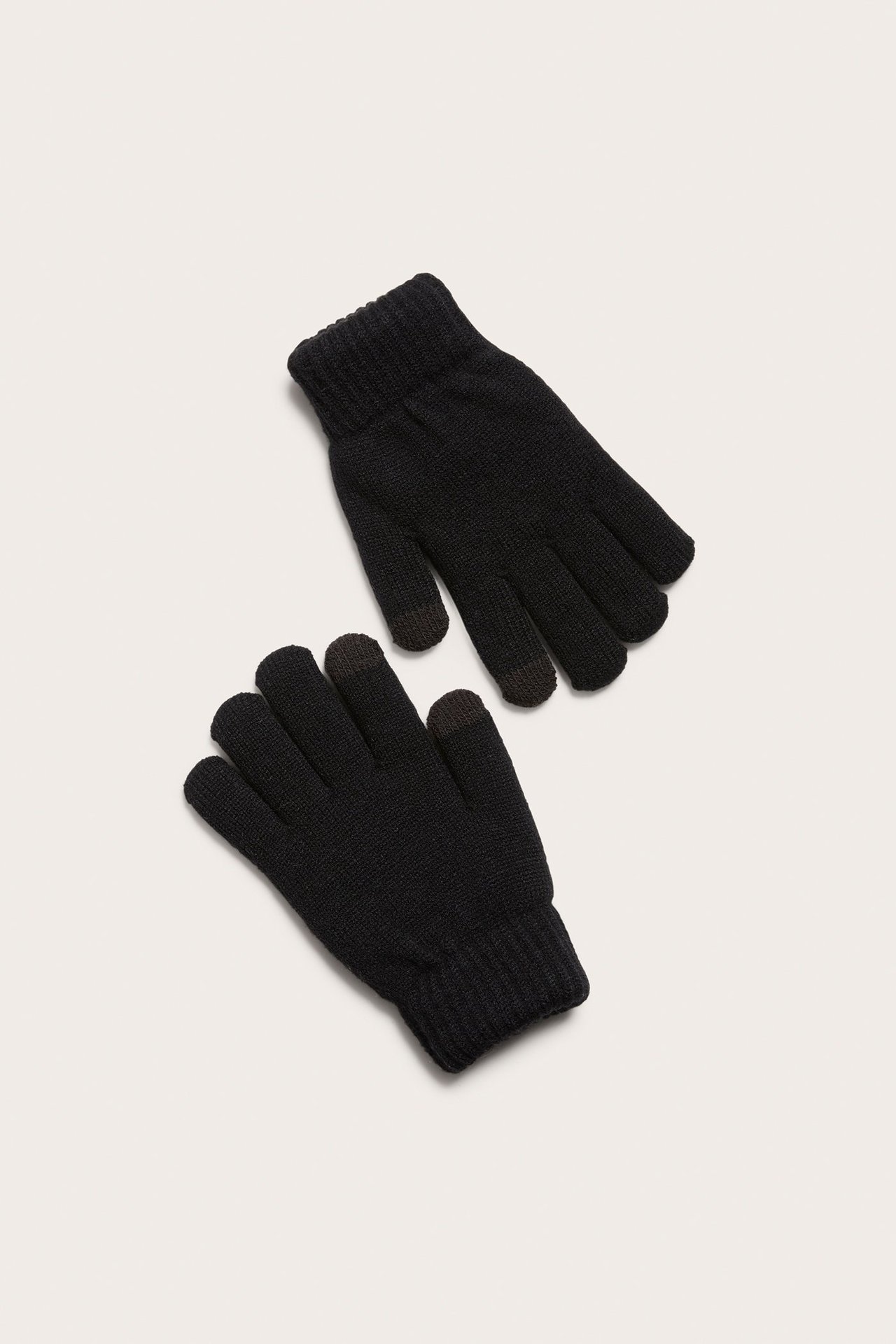 Uppifrån-vy av ett par svarta stickade touchscreen-vantar med ribbade muddar och mörka fingertoppar.