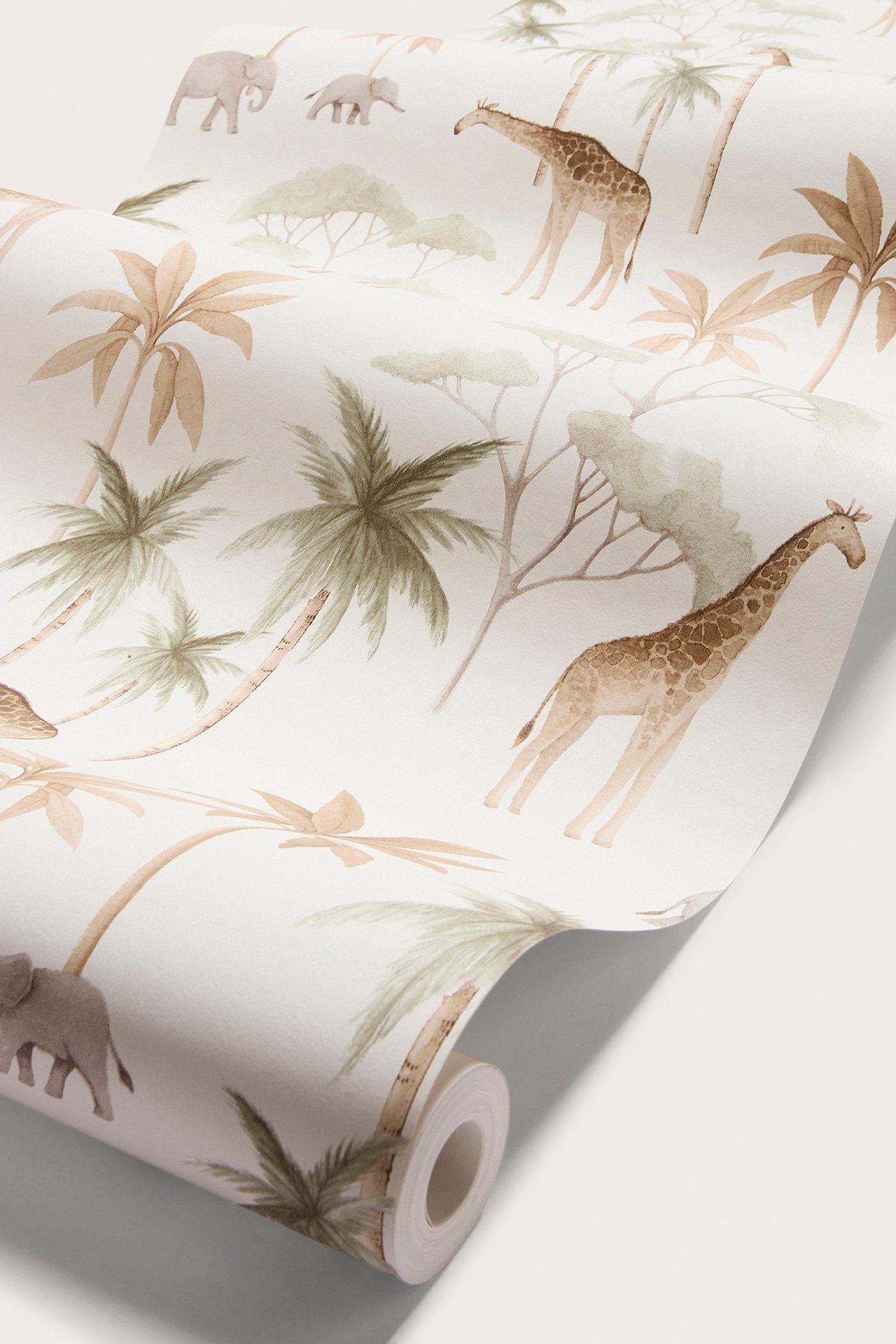 Närbild av vit tapetrulle med savanndjurmönster: giraffer, elefanter och palmer i dämpade toner.