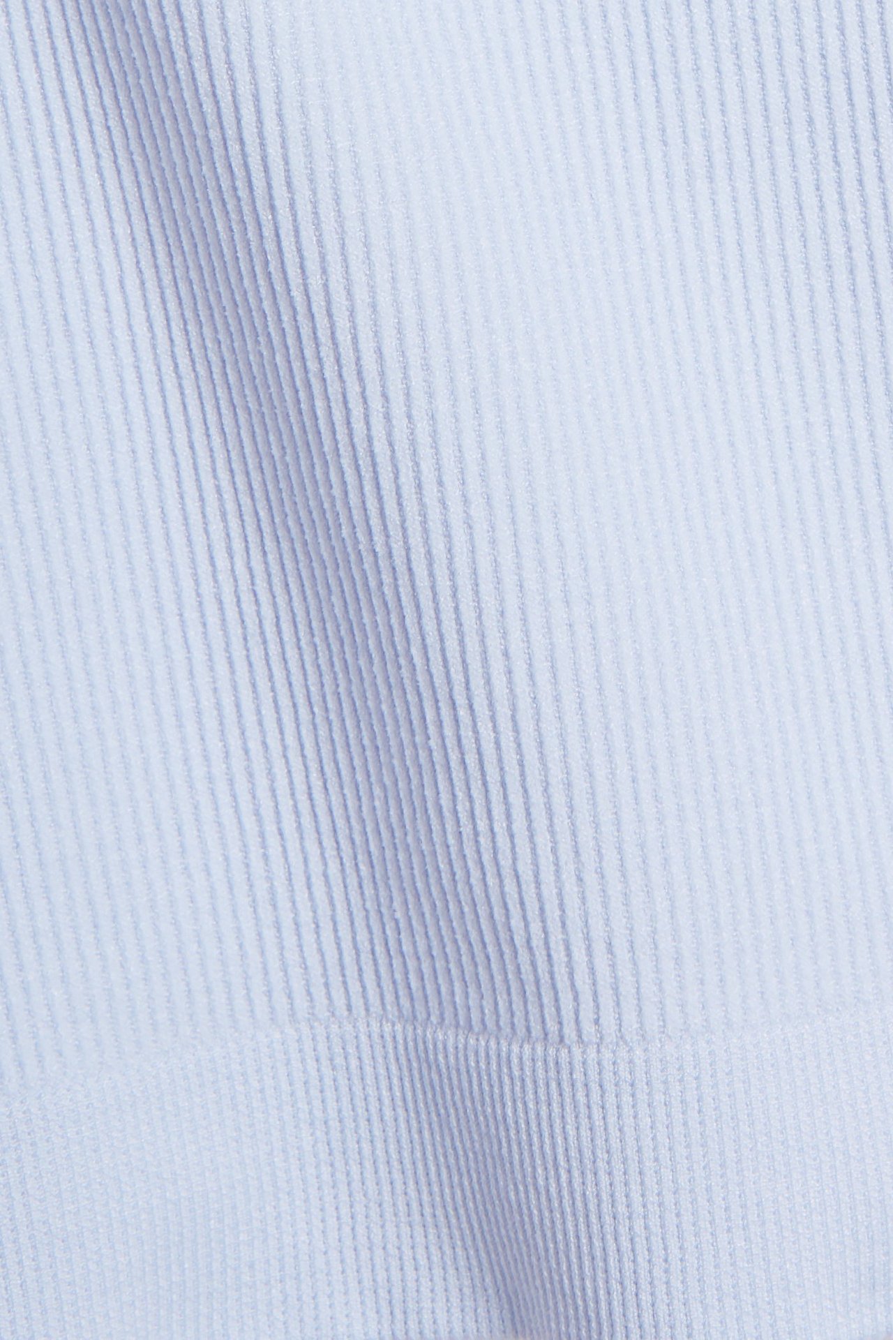 Zbliżenie na jasnoniebieski bezszwowy top w prążki z elastanu i poliamidu.