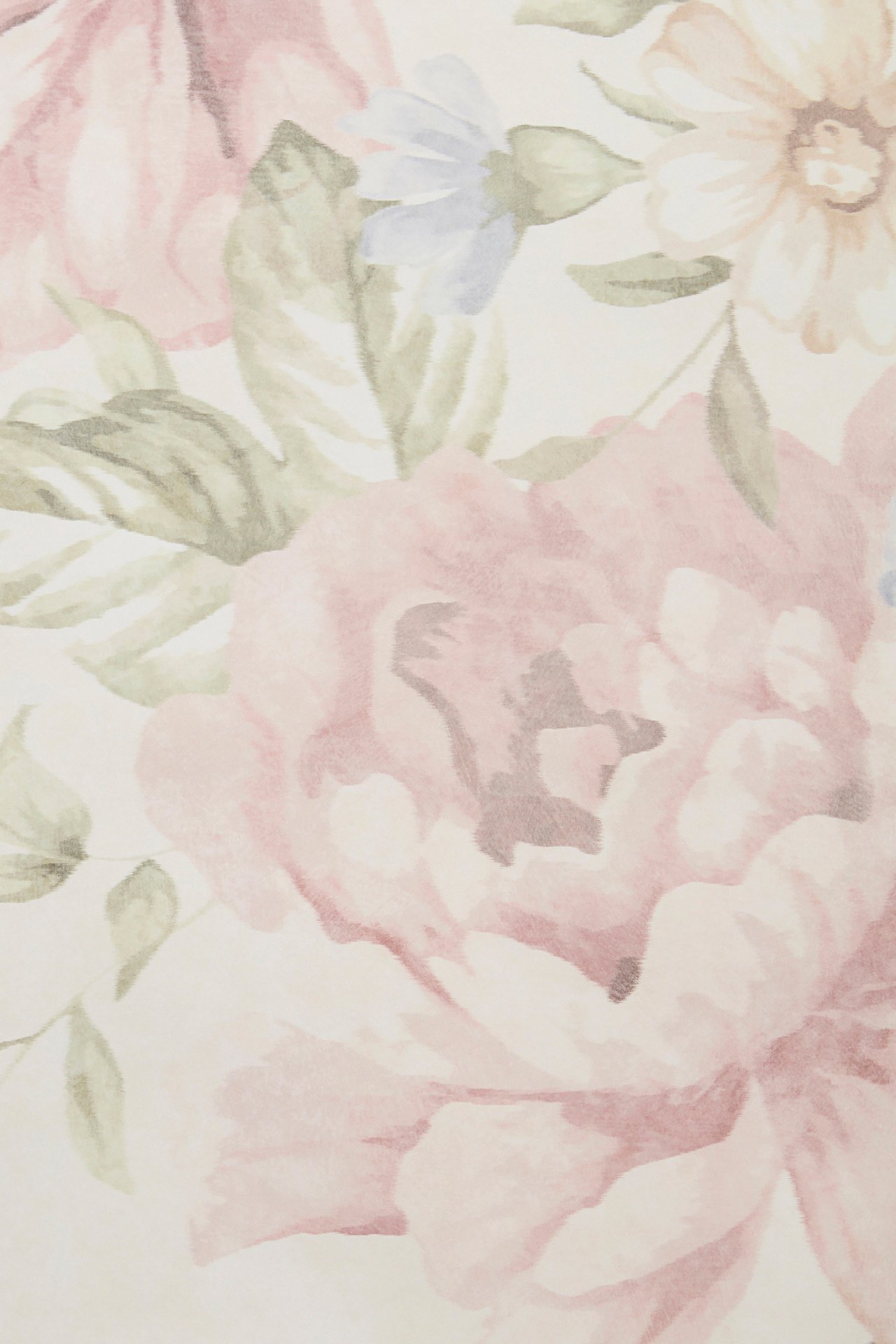 Zbliżenie beżowej papierowej tapety ściennej z kwiatowym wzorem w kolorze różowym, zielonym i jasnoniebieskim.