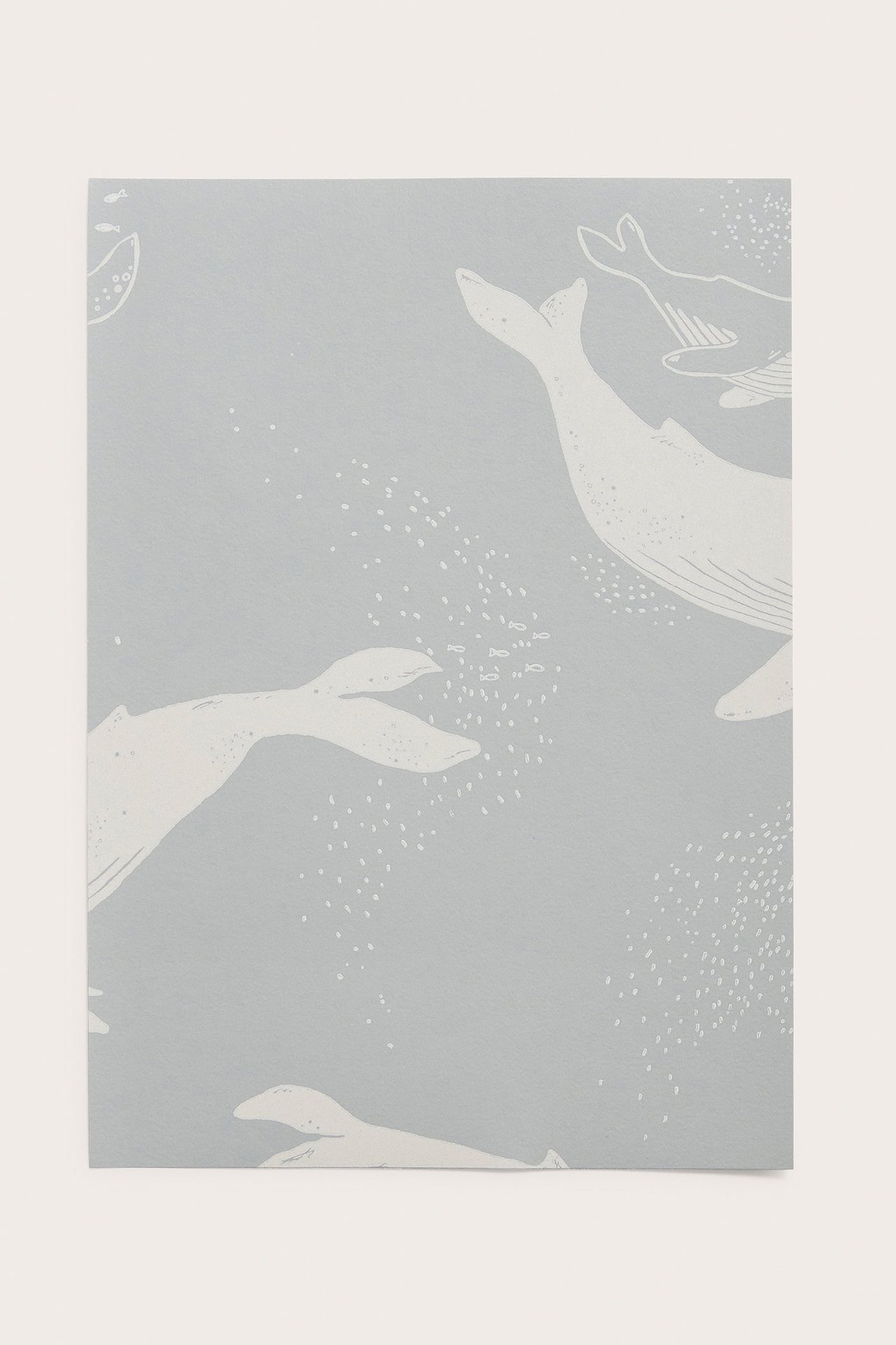 Närbild av ett ljusblått tapetprov i papper med vitt valmönster och små bubblor.