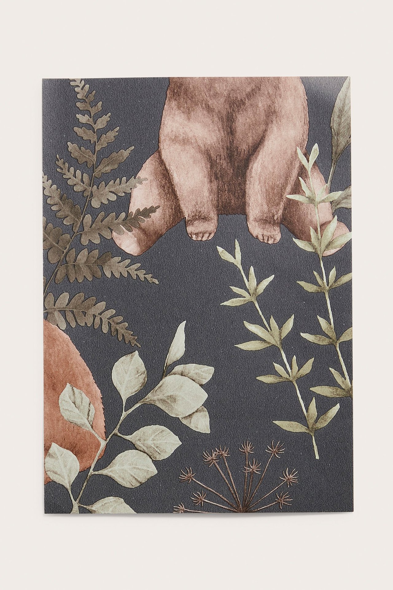 Lähikuva tummansinisestä kuitukangastapetista, jossa on ruskea karhu ja metsäaiheinen kuvio.