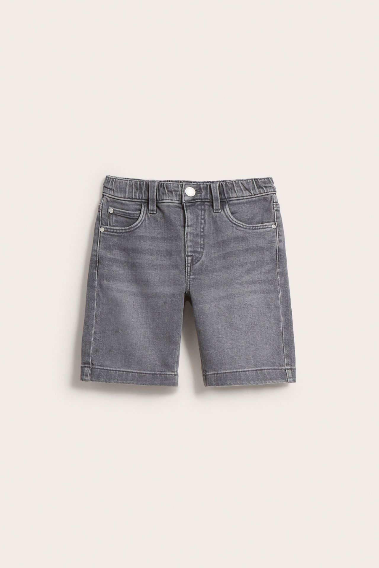 Frontvy av stretchiga jeansshorts för barn i ljusgrå denim med tryckknapp och resår i midjan.