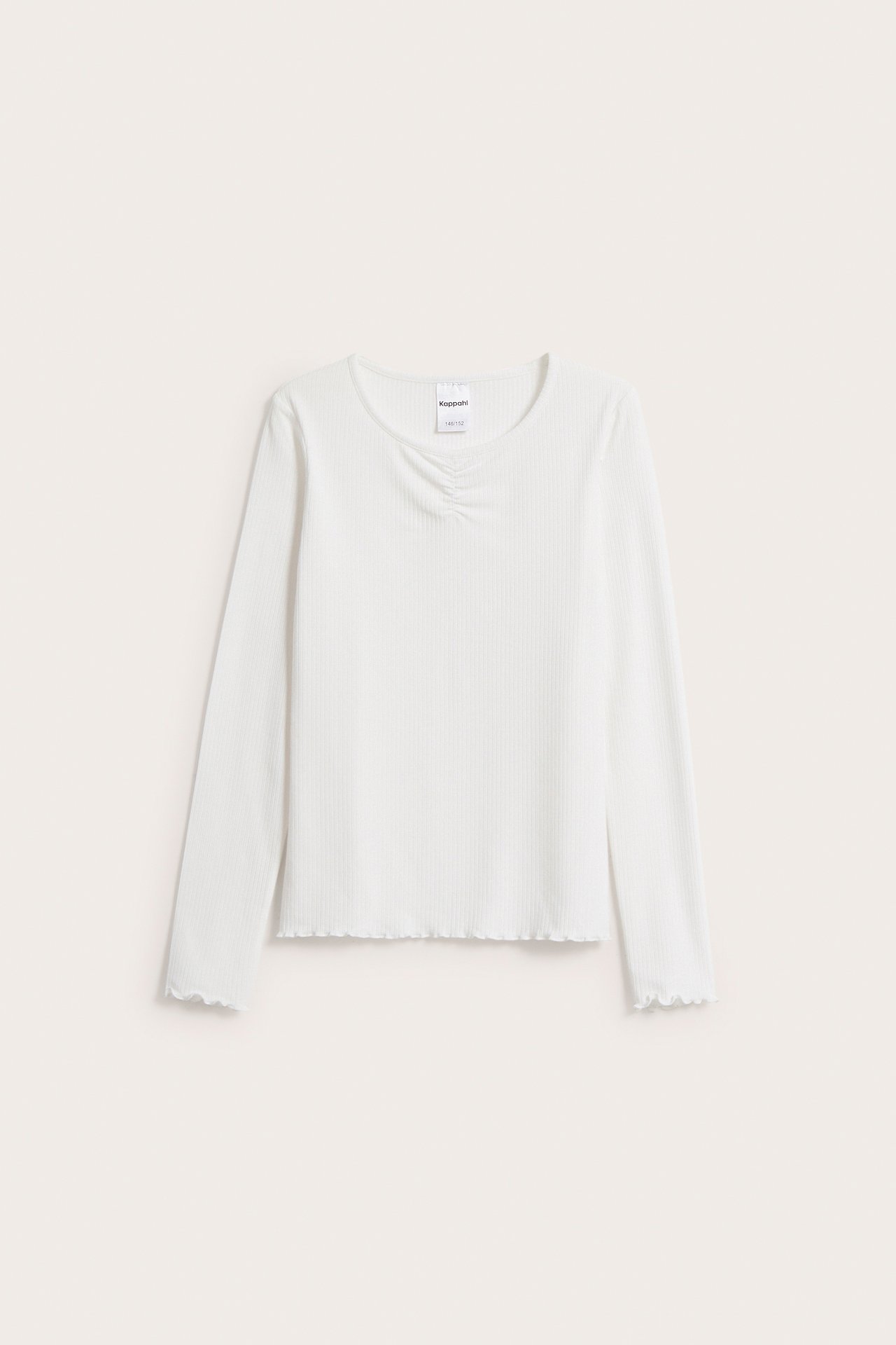 Framifrån, offwhite ribbad långärmad pyjamastopp med rynk framtill och vågiga kanter.