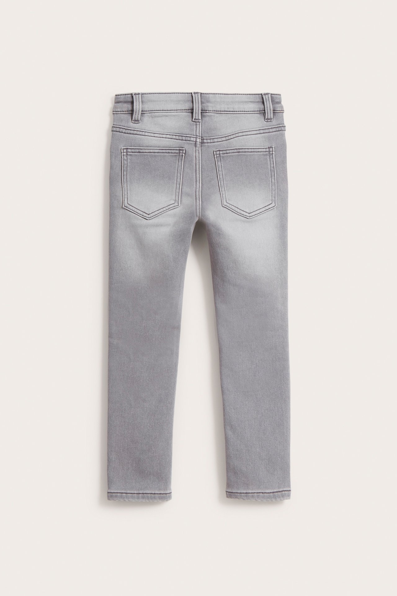 Bakifrån, barnens gråa slim jogger denimjeans med två bakfickor.