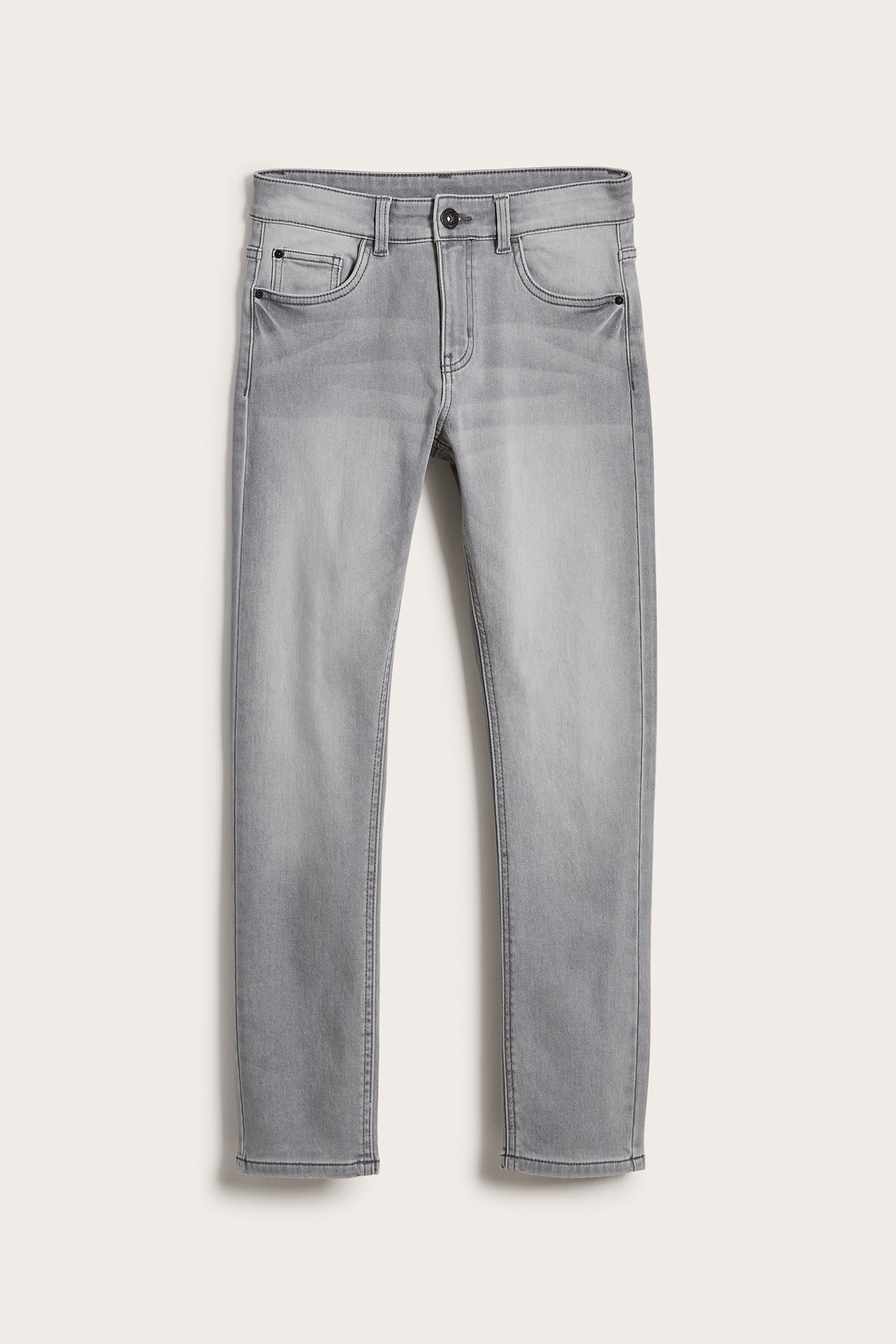 Framifrån, gråa slim-fit jogger denim jeans med fem fickor och knäppning.