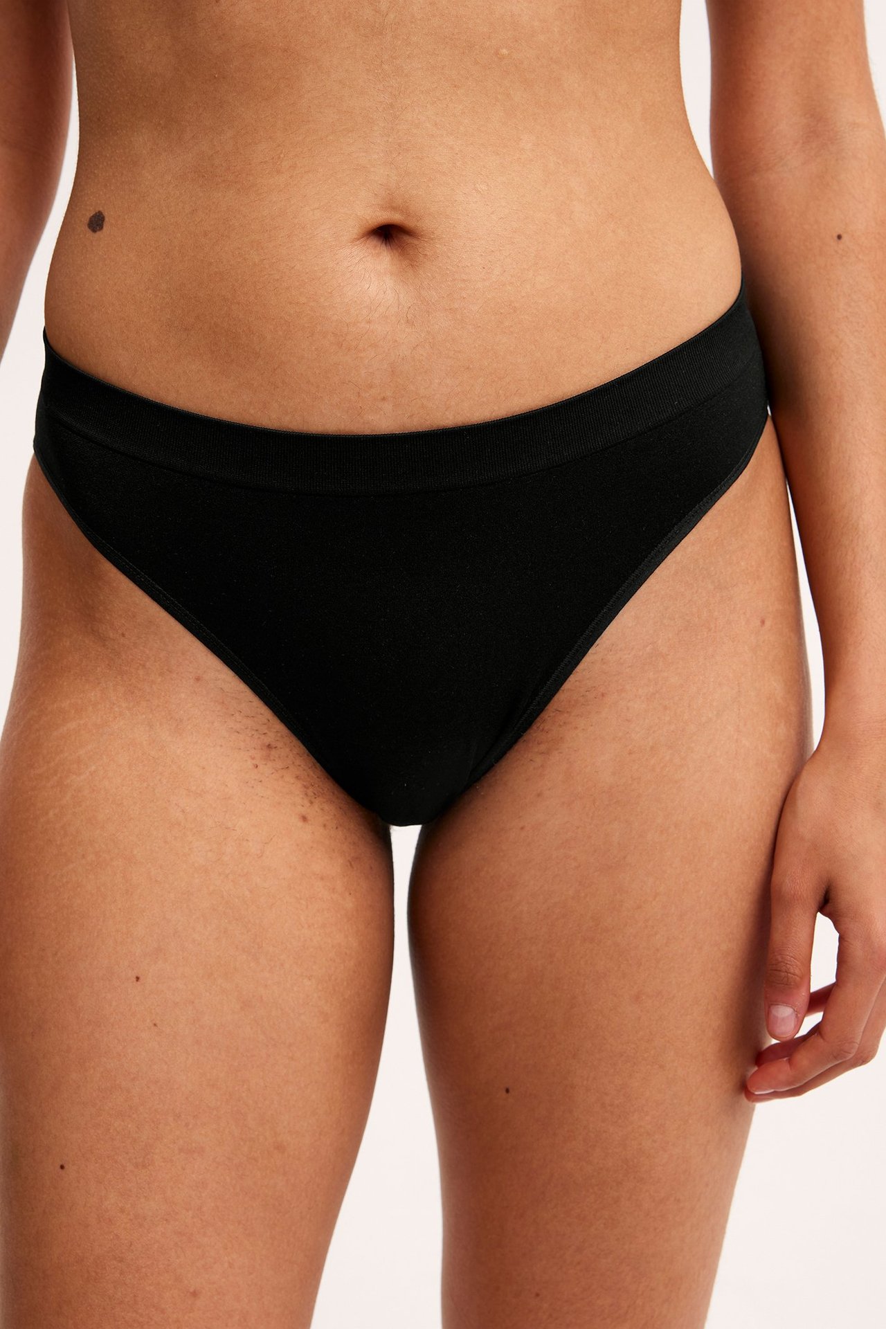 Edestä, nainen mustissa polyamidi/elastaani brief-alushousuissa, joissa on resori vyötäröllä.
