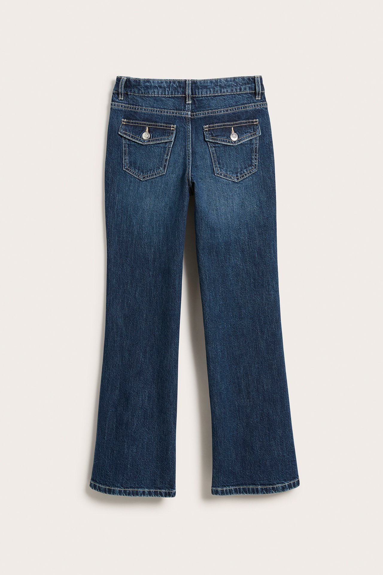 Widok z tyłu ciemnych dżinsów bootcut dla dzieci z kieszeniami z klapkami i guzikami.