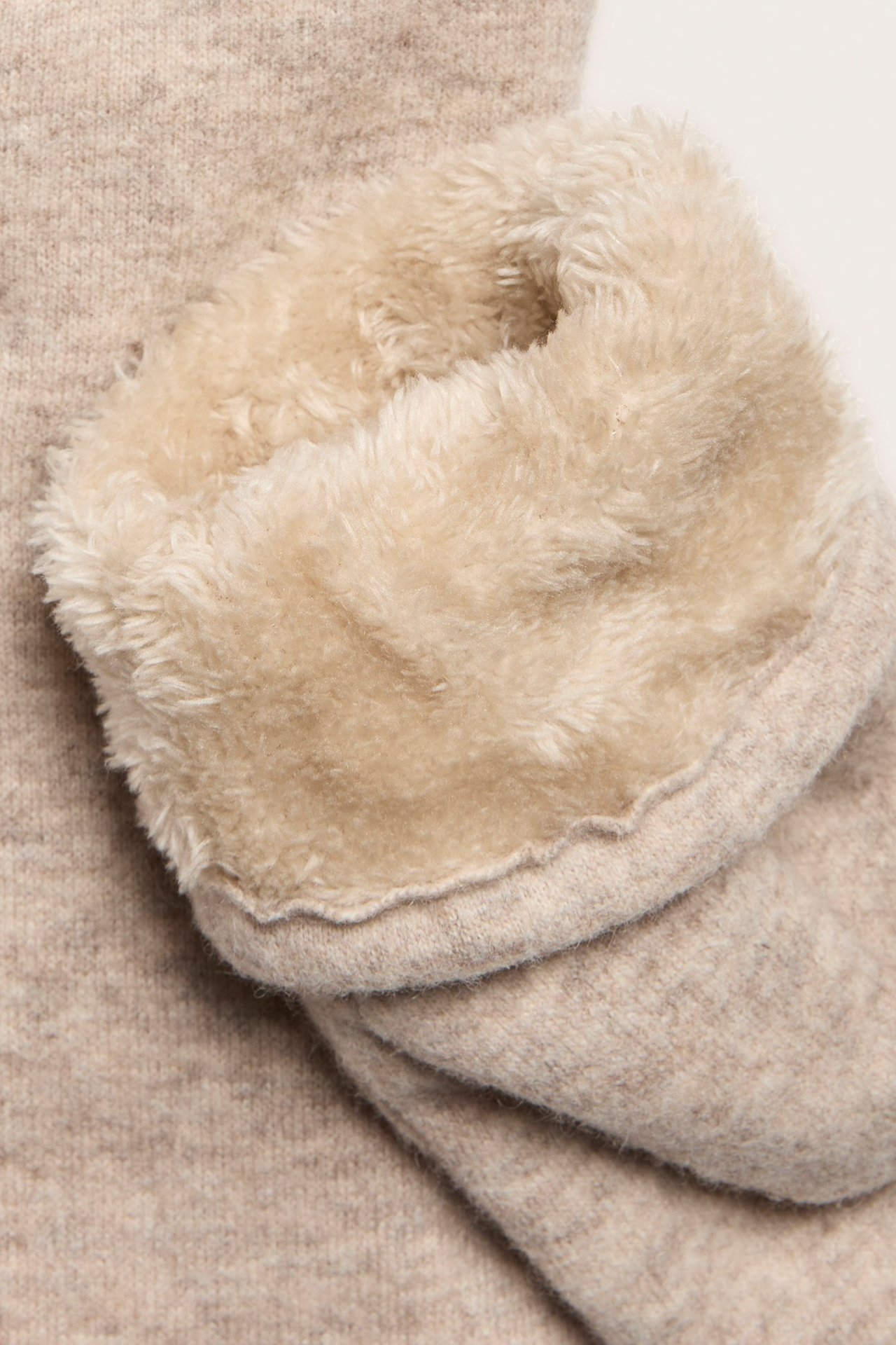 Lähikuva beigestä villasekoitetumput, jossa on pörröinen vaaleanbeige teddyvuori.