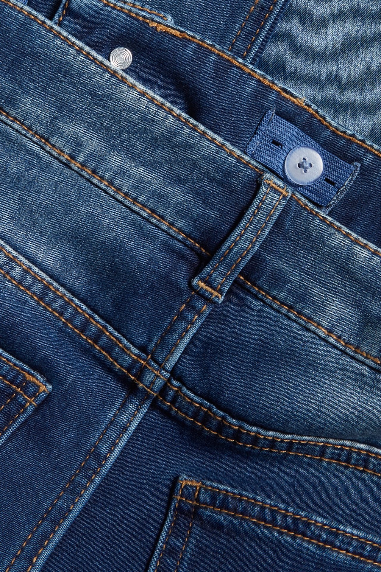 Lähikuva lasten sinisistä jogger denim slim -farkuista, joissa säädettävä kuminauhavyötärö ja tikkaukset.