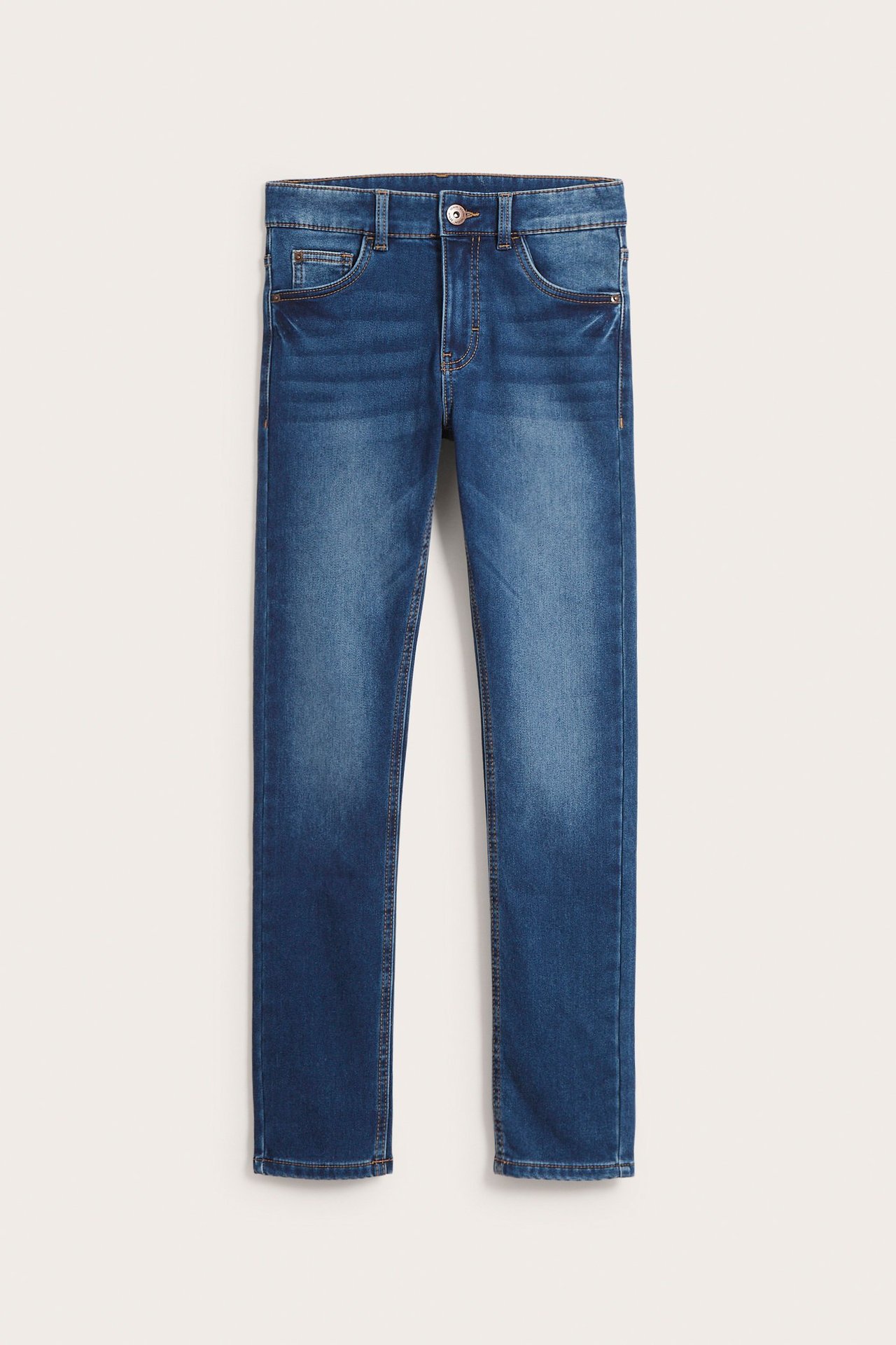 Edestä näkymä lasten sinisistä X-slim jogger denimfarkuista, joissa on viisi taskua ja nappikiinnitys.