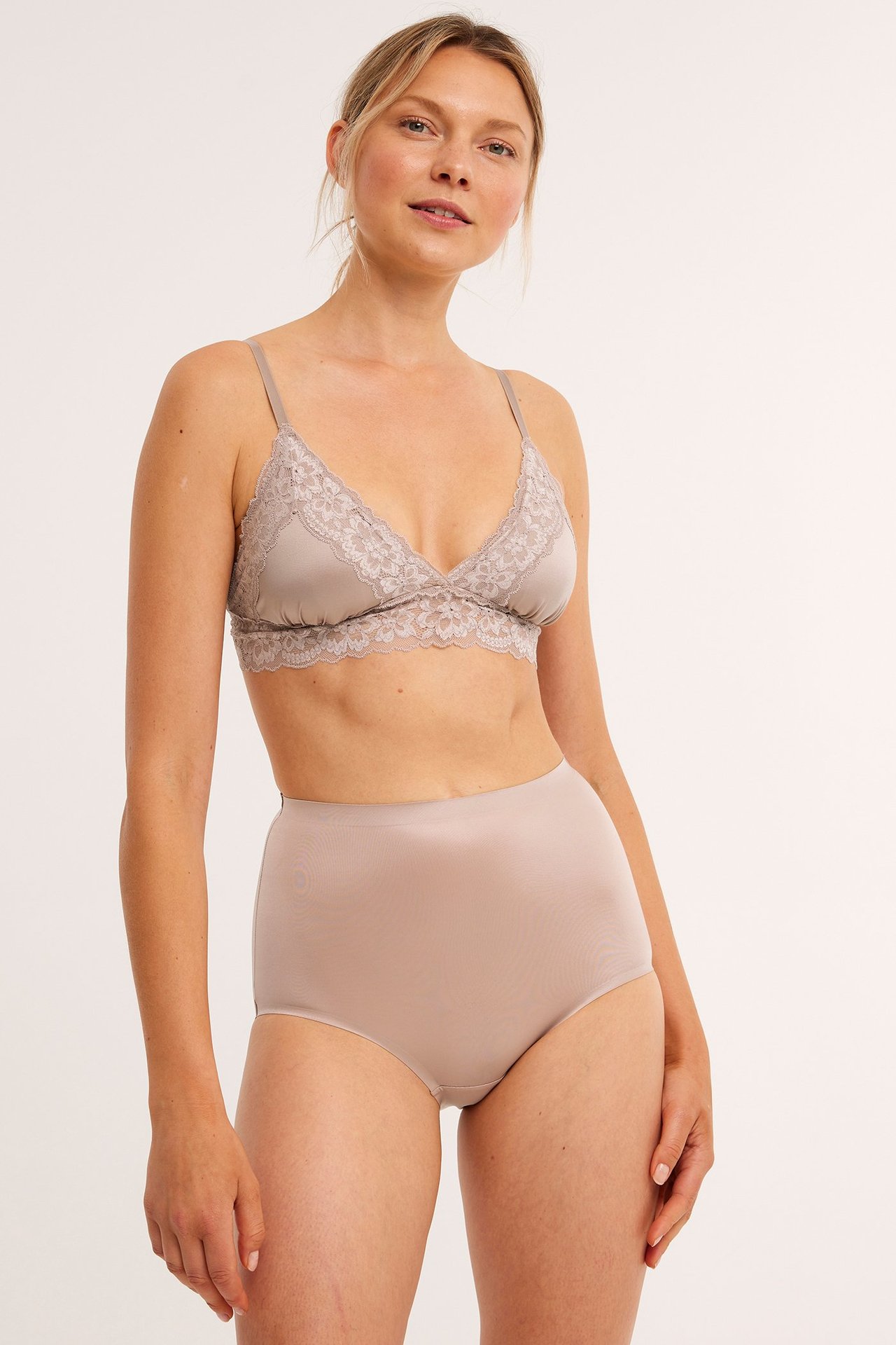 Forfra: kvinne i lyserosa høytlivs shapingtruse og matchende blondebralette.