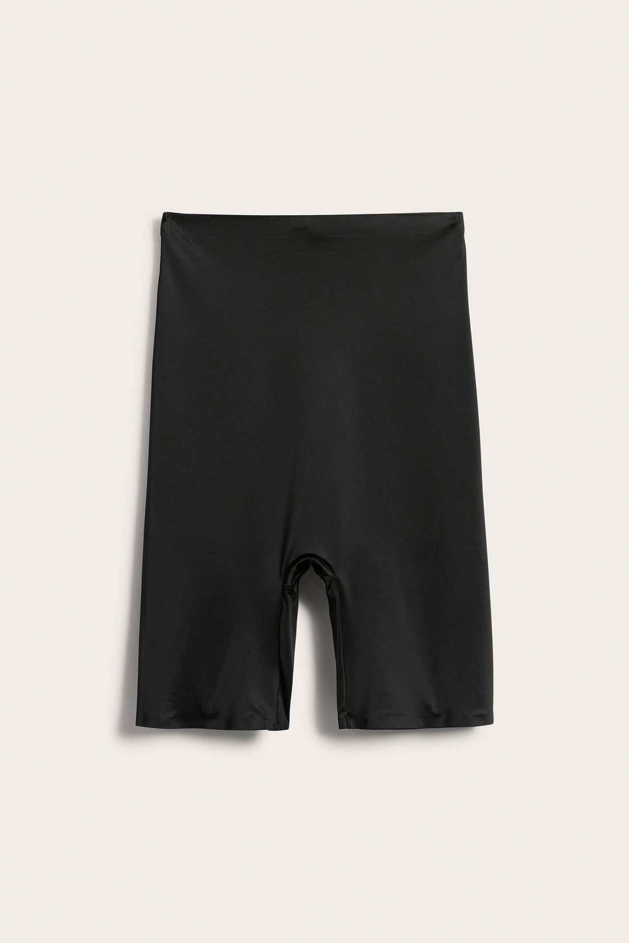 Frontvisning av svarte høytlivs shapingshorts i satinmicro med sømløse kanter, flatt lagt.