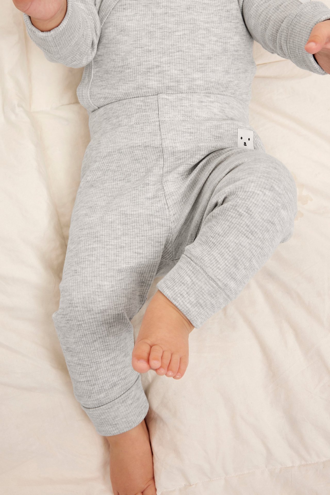 Lähikuva vauvasta yllään vaaleanharmaat meleeratut ribbileggingsit, joissa on reilut resorit ja yhteensopiva toppi.