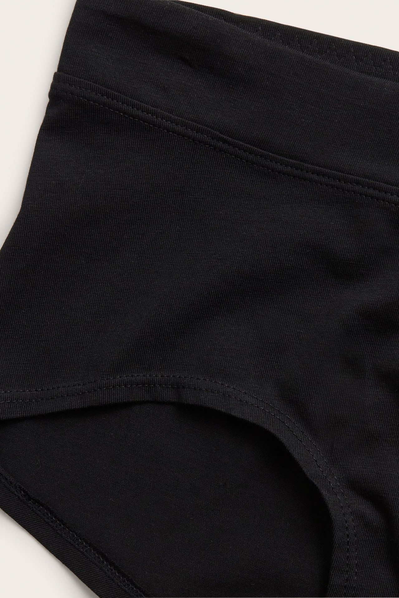 Zbliżenie na czarne figi typu hipster z miękkiej mieszanki bawełny z szerokim pasem.