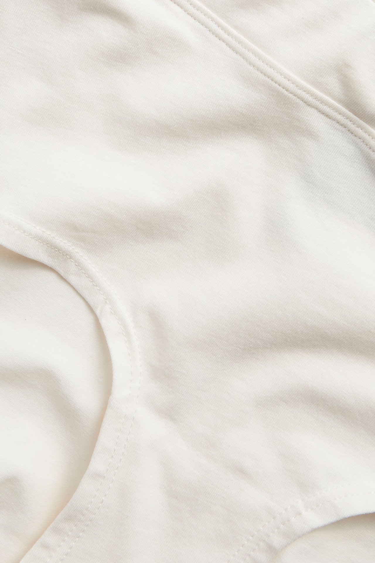 Zbliżenie białych majtek typu hipster z miękkiej mieszanki bawełny, ukazujące fakturę i szwy.