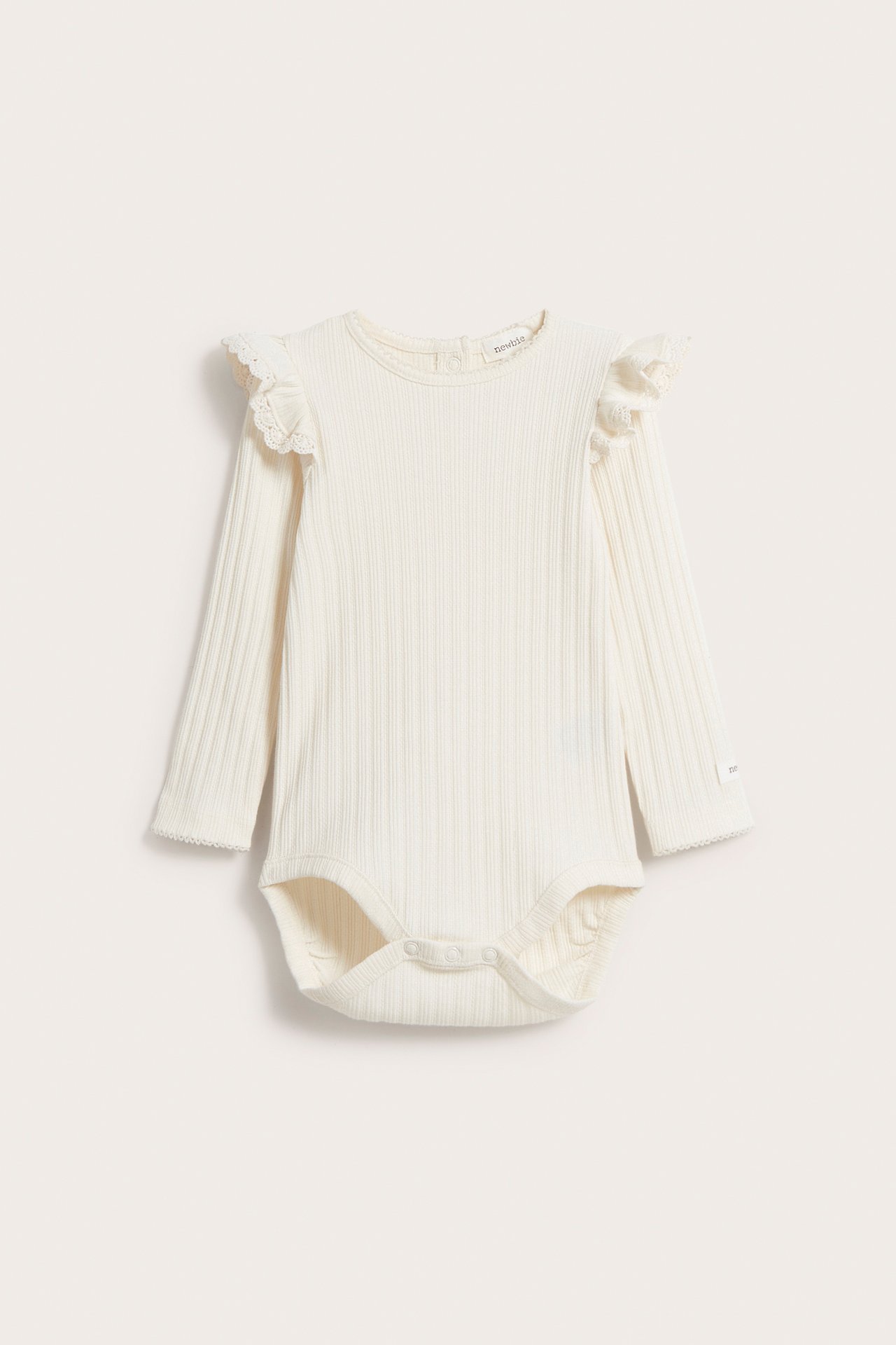 Frontvisning av en offwhite ribbet babybody med lange ermer, blondekantede skulderfriller og trykknapper.
