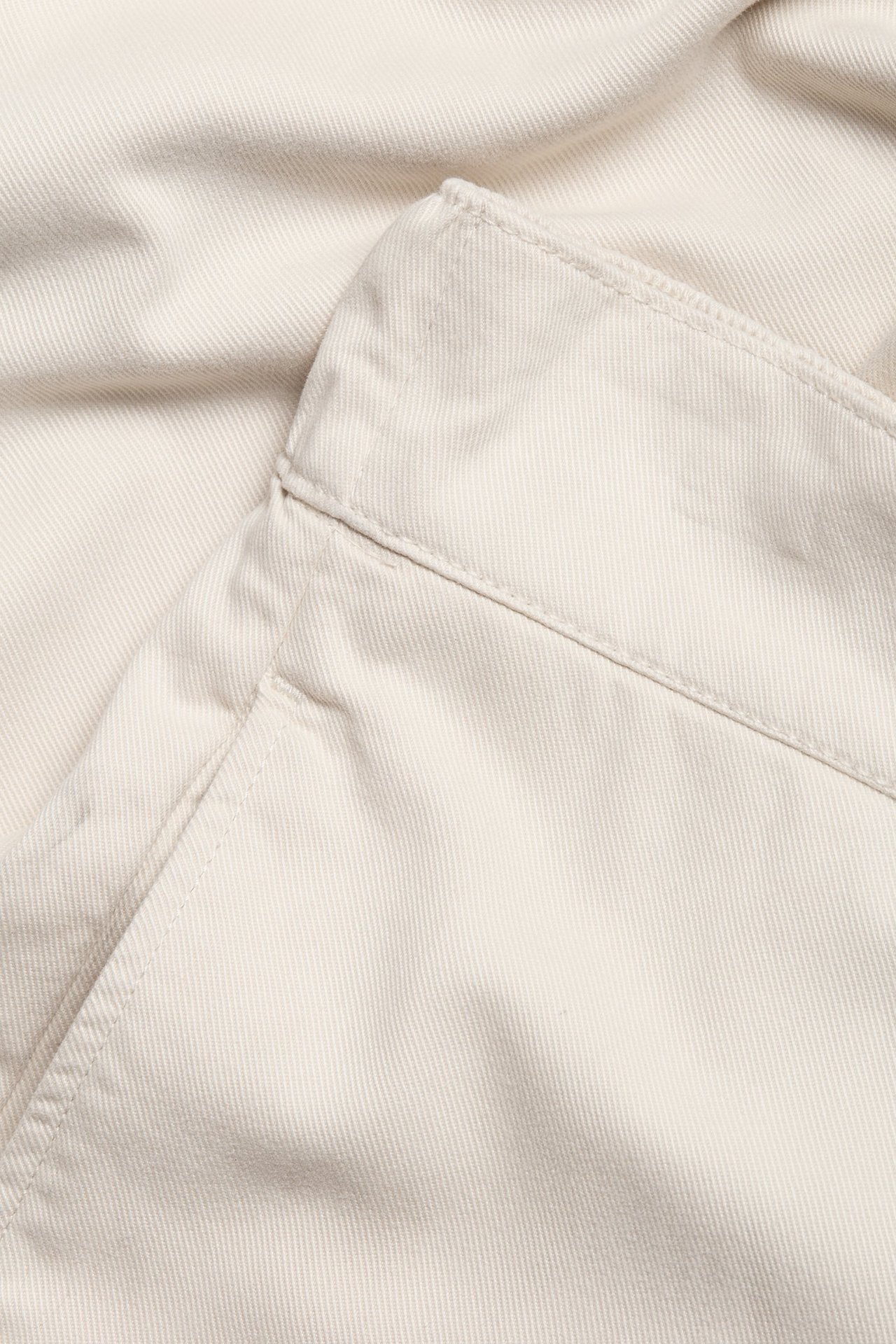 Zbliżenie jasnobeżowych spodni pull-on z mieszanki bawełny i lyocellu, widoczny pas i kieszeń boczna.