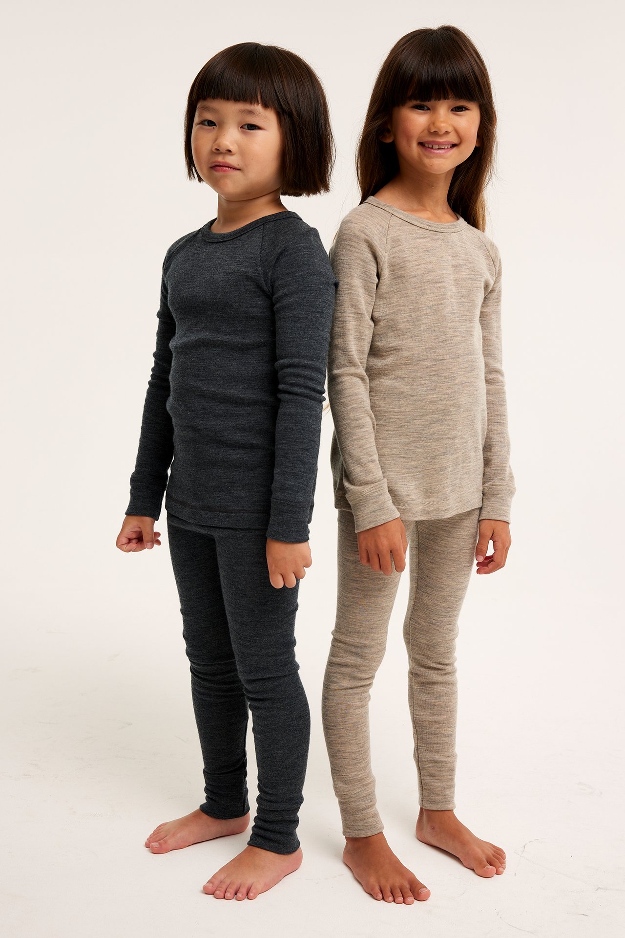 Forfra: Barn i beige melert merinoull understellsett, et annet barn i mørkegrått sett.