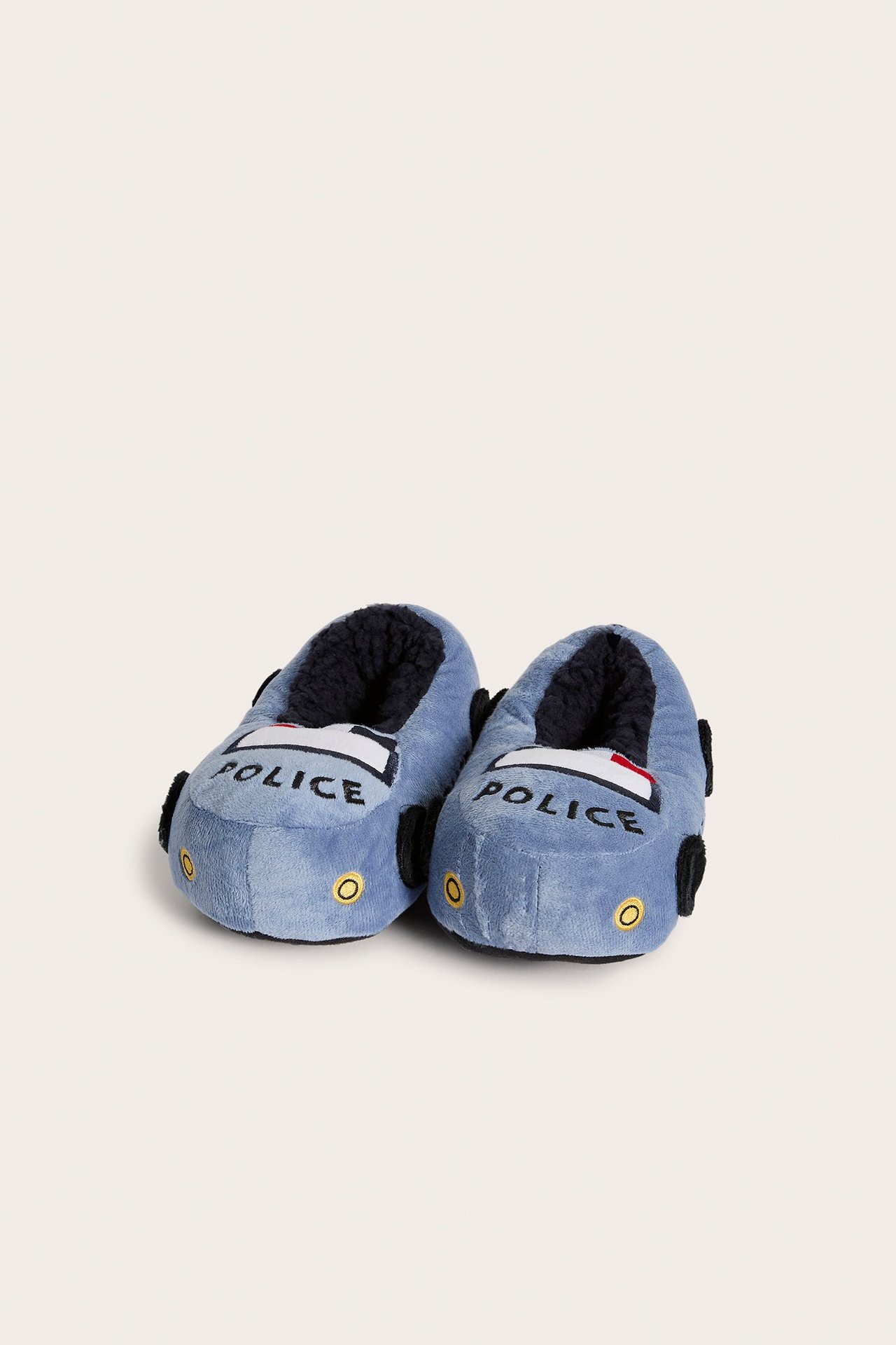 Edestä: siniset lasten tossut, jotka on muotoiltu poliisiautoiksi, joissa on 'POLICE'-teksti ja musta fleecevuori.