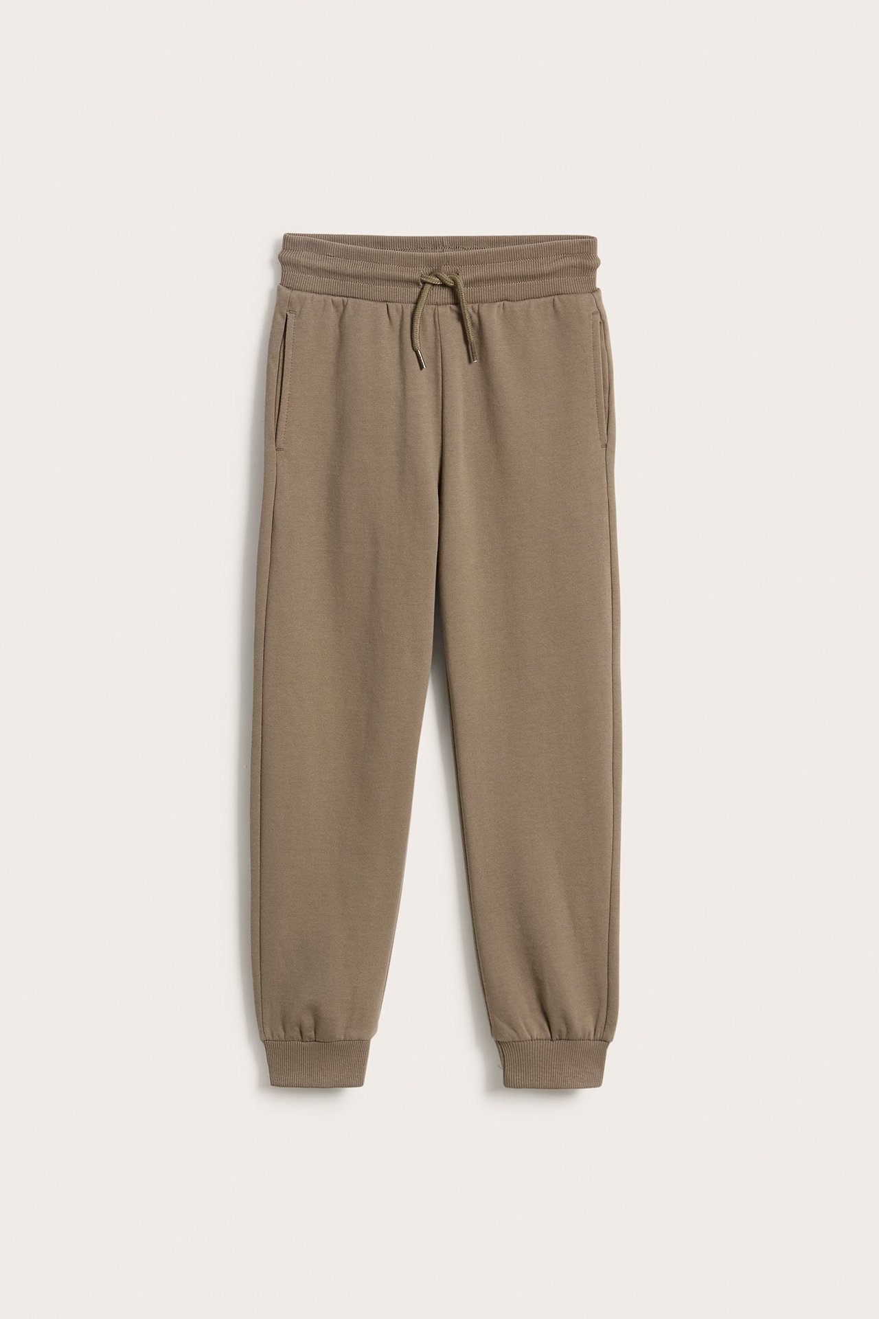 Widok z przodu brązowych bawełnianych spodni dresowych z prążkowanym pasem, sznurkiem i kieszeniami.