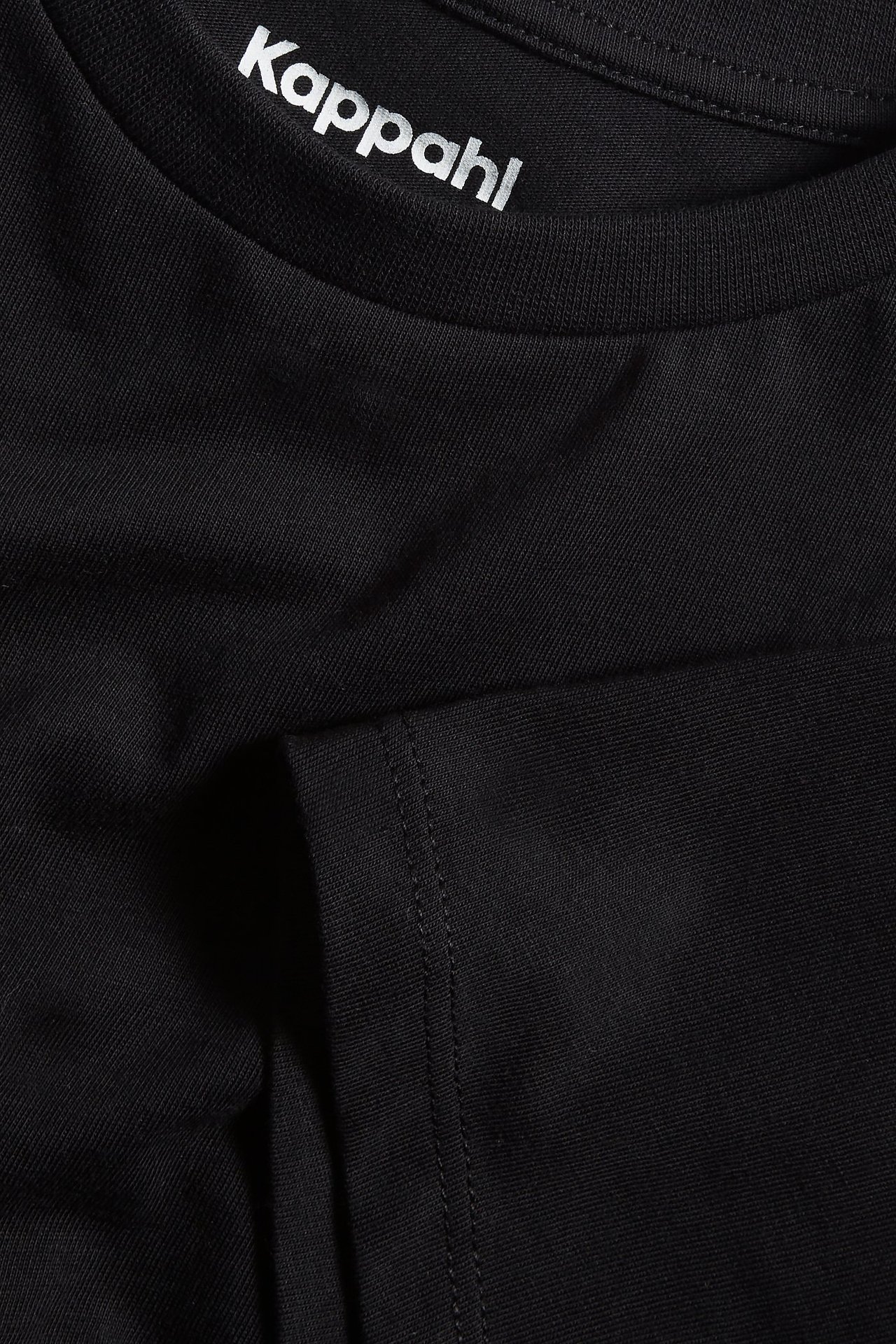 Zbliżenie czarnego, jednolitego bawełnianego T-shirtu z prążkowanym dekoltem.