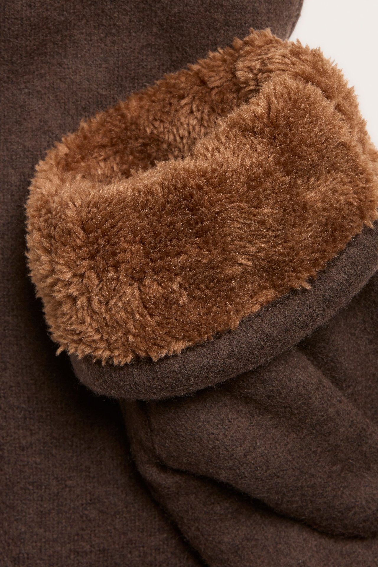 Zbliżenie brązowego melanżowego rękawiczki z jednym palcem z wełny z jasnobrązową podszewką teddy.